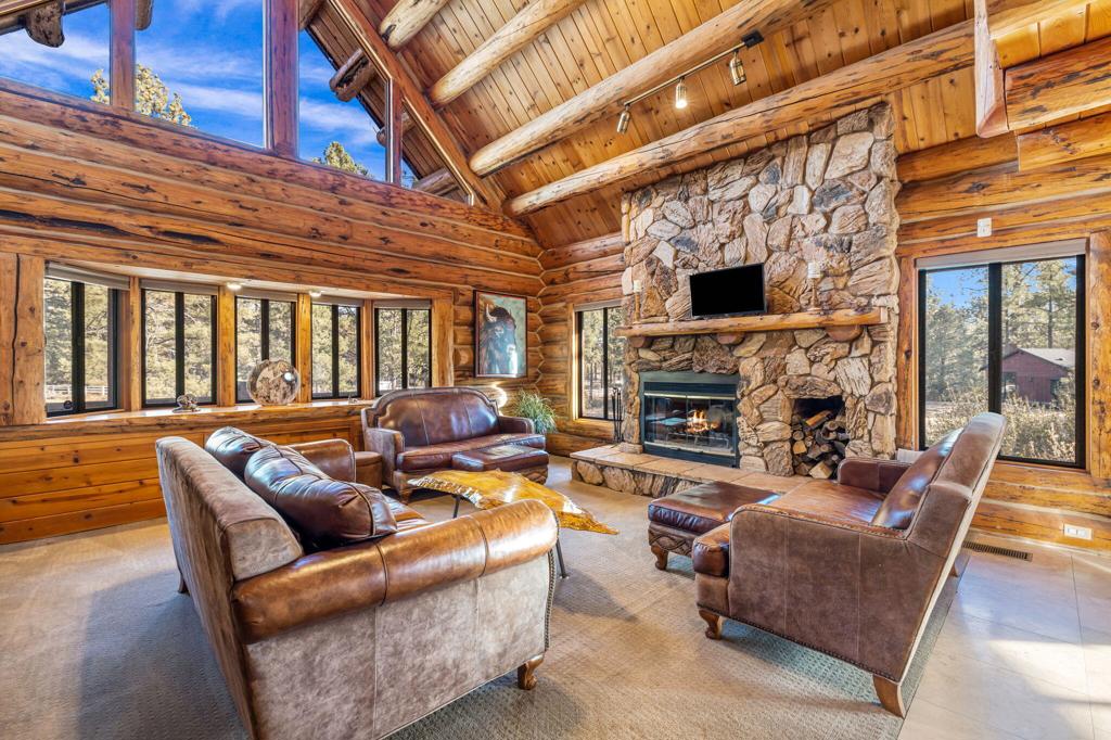 Discover your own slice of Garner Valley paradise with this remarkable custom log home, nestled at the end of a cul-de-sac amidst tall pines and majestic oversized boulders. Offering a generous 3,746 square feet of living space, this unique three-story residence features 4 spacious bedrooms and 4 bathrooms, thoughtfully designed for comfort and versatility. Marvel at the exquisite craftsmanship throughout, from the gorgeous hand-hewn beams to the soaring high ceilings. The massive stone fireplace serves as the heart of the living room, providing warmth and charm. The oversized kitchen is a culinary dream, equipped with newer countertops, sink, and appliances, ready for your holiday gatherings. Each floor hosts bedrooms. The bottom floor could easily serve as a separate apartment. All plumbed and wired for a kitchen with its only laundry room and separate entrance. The third story adds versatility with two additional potential bedrooms or flex spaces. Whether a full-time residence or a part-time retreat, this home has it all. Outside, your 5.36-acre lot invites exploration. Whether you're hosting a barbecue on the deck, exploring your fully fenced back yard, wandering the horse trails, or simply soaking in the serenity of your private outdoor space, this property is your canvas. Garner Valley HOA includes a community common building, 26 miles of horse riding trails, and a community arena. Saddle up and embrace the Mountain Center lifestyle--your adventure awaits!