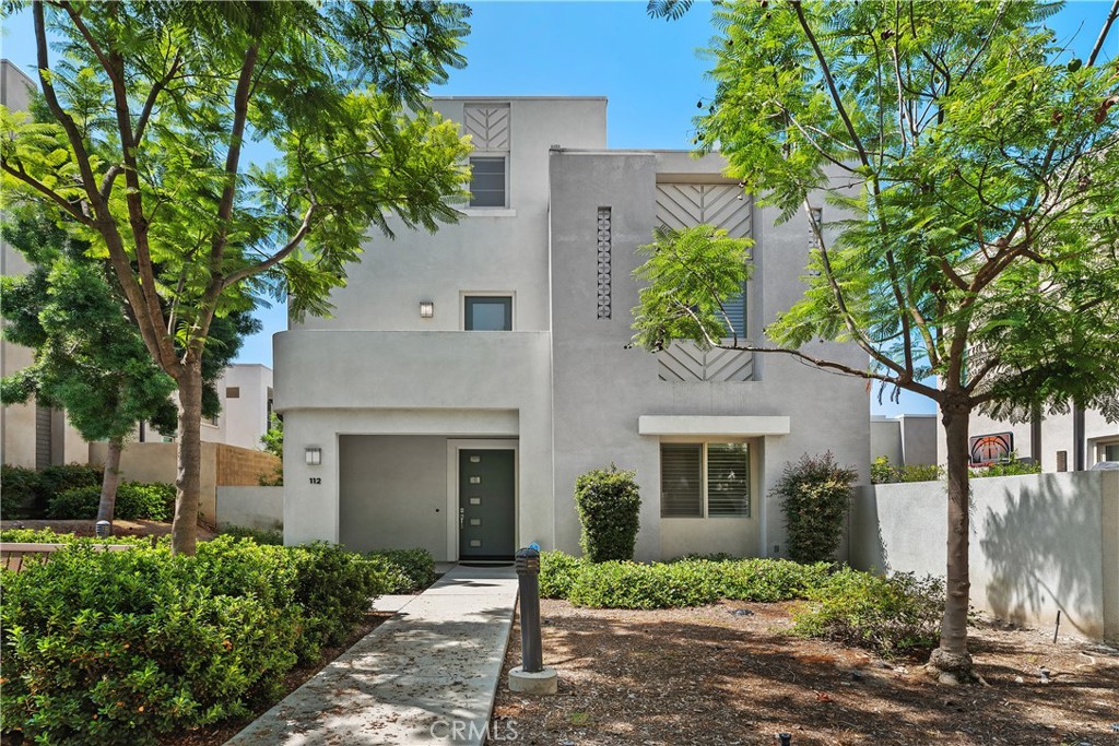 Experience the perfect blend of style, comfort, and convenience in this stunning tri-level detached home located in the sought-after Parasol Park community. The main floor features a bright and airy open layout with a spacious living room and a gourmet kitchen with a large center island perfect for cooking, entertaining, or casual dining. A bedroom and full bathroom on this level make it ideal for guests, extended family, or a private home office. Elegant bi-fold doors seamlessly connect the indoor space to a covered patio and a beautifully hardscaped, low-maintenance backyard perfect for relaxed evenings or weekend gatherings. On the second floor, the luxurious primary suite offers a private outdoor balcony, a spa-inspired bath with a deep soaking tub, rain head shower, premium tile flooring, and upgraded cabinetry. A secondary bedroom with its own full bath and a convenient laundry room with sink are also located on this level. For your convenience, the home comes complete with a washer, dryer and refrigerator., The third floor is an entertainer’s dream a versatile bonus loft that can be transformed into a media room, office, or lounge. Step out through sliding doors to the California Room, a covered rooftop retreat where you can savor breathtaking panoramic views. Perfectly positioned within the community, you’ll be just steps from schools, scenic parks, and top-tier amenities including pools, spas, basketball courts, and playgrounds. Located within Irvine’s award-winning school district and zoned for the highly regarded Portola High School. Only a 5-minute drive to Woodbury Town Center and 10 minutes to Irvine Spectrum. This is more than a home it’s a lifestyle. Don’t miss the opportunity to make it yours.