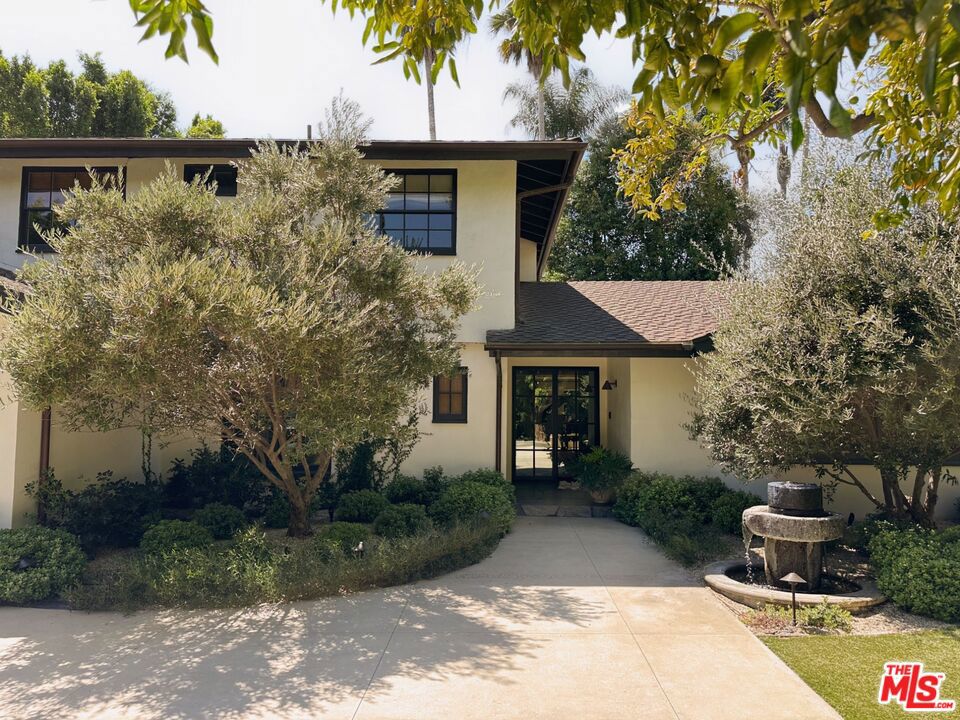 Experience sophisticated design, unparalleled comfort, and privacy at this reimagined celebrity compound in Sherman Oaks, South of the Boulevard. This residence, recently redone to perfection by renowned interior designer Chad Wood, spans approximately 3,400 sqft and features 4 bedrooms and 4 bathrooms on a generous 13,457 sqft flag lot. A 120-foot-long gated driveway and lush greenery ensure ultimate privacy. Pass through two elegant olive trees to discover a home adorned with exquisite finishes, including imported Spanish wide-plank natural oak hardwood floors that exude luxury and refinement. The professional-grade kitchen is equipped with Viking appliances and an oversized hardwood island. The spacious great room boasts a fireplace, skylights, walls of glass, and French doors leading to the backyard. The outdoor oasis features a large patio for al fresco dining, a swimming pool, spa, and a flat lawn, creating a perfect retreat for relaxation and entertainment. This exceptional property provides a private sanctuary that embodies the pinnacle of modern elegance in the heart of Sherman Oaks.