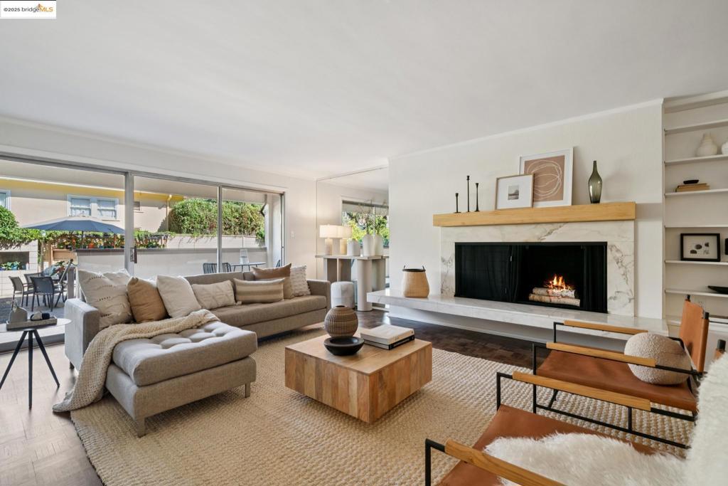Beautifully remodeled corner-unit, one-level condo situated in an exceptional North Berkeley location. The gracious living room features a wall of bookcases, a classic raised-hearth mid-century modern marble fireplace and beautifully refinished parquet hardwood floors that extend into the sunny dining room. Adjacent to the dining area is a dedicated office space—ideal for working from home or creative pursuits. The recently remodeled eat-in kitchen offers stainless steel appliances, quartz countertops, and ample storage. Both bathrooms have been thoughtfully updated with designer tile, elegant vanities, and contemporary lighting; the primary bathroom also features a soaking tub. The ensuite primary bedroom features a large window that fills the space with natural light and includes a walk-in closet. Both the living room and second bedroom open directly onto the building’s large outdoor patio and pool—an exceptionally rare amenity in Berkeley and a lovely space for gatherings. Across from the JCC and around the corner from Thursday farmer's market, Chez Panisse, Cheeseboard Collective, Peet's, Saul’s, also close to Live Oak Park. Includes one-car deeded parking in a secure garage and a dedicated storage space. A seamless blend of expansive living, stylish comfort, and convenience.