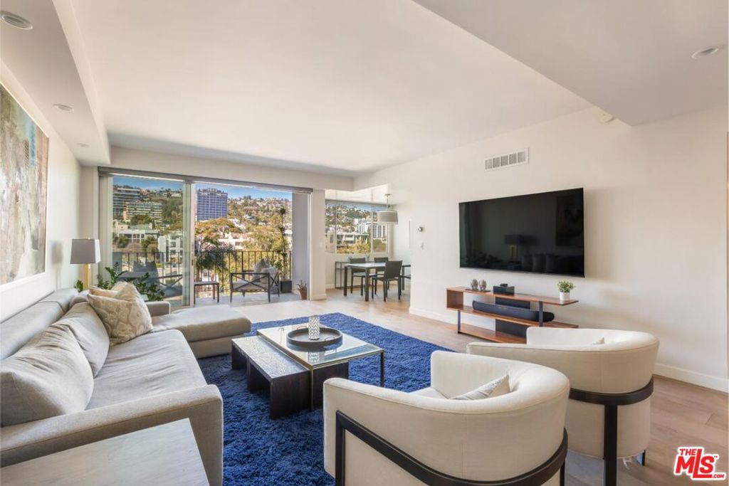 This modern pied-a-terre in the highly sought-after Doheny Plaza delivers immersive views of the city and the Sunset Strip. Situated on the border of Beverly Hills and West Hollywood, this iconic 13-story mid-century building, completed in 1963, offers a seamless blend of timeless design and modern convenience. Doheny Plaza provides a full-service, low-maintenance, luxurious urban lifestyle with 24-hour valet-parking, a newly renovated fitness center, a sparkling salt water pool, a conference room, and three guest suites available for visitors at a nominal fee per night. This renovated, north-facing residence features an open floor plan with two bedrooms, two bathrooms, and abundant natural light all throughout. Designed for both comfort and functionality, the spacious living area flows into a modern kitchen equipped with sleek cabinetry and high-end stainless steel Bosch appliances. The primary bedroom boasts generous closet space and an en-suite bathroom. Floor-to-ceiling sliding doors lead to a private balcony and frame panoramic city views that stretch across the Sunset Strip. With most utilities covered by HOA dues, residents enjoy effortless living with included water, electricity, and heating/cooling, along with 24-hour front desk service and secured parking. Just steps from LA's most exclusive social clubs, including Soho House, San Vicente Bungalows, The Bird Streets Club, and the world class dining and shopping Sunset Plaza living has to offer.