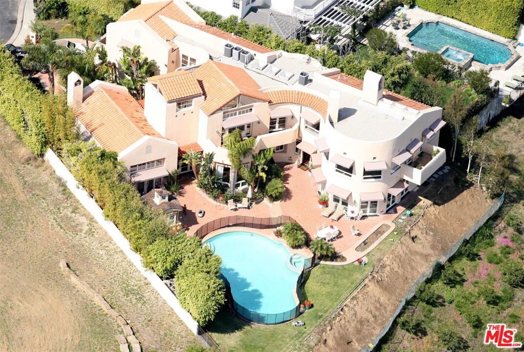 An extraordinary opportunity awaits to create a world-class estate in one of Pacific Palisades' most coveted and prestigious 24 hour guard gated enclaves, Ridgeview Country Estates, known for its privacy, exclusivity, and architectural pedigree. The property is offered with a complete set of architectural plans by legendary architect Richard Landry, whose work defines Southern California luxury living. These plans establish a bold and sophisticated vision while still allowing the future owner to imprint their own style and lifestyle needs. Perfectly positioned at the end of a serene cul-de-sac, this approximately 1.42-acre estate site (per assessor) offers both seclusion and stature, surrounded by some of the area's most remarkable residences. The seller is actively securing permits for a substantial retaining wall designed to expand the flat pad from the current approximate 15,000 sq. ft to approximately 20,000 sq. ft., dramatically increasing the property's usable outdoor space. The envisioned grounds will accommodate an infinity-edge pool cascading toward canyon and peek-a-boo ocean views, with abundant space for grand-scale entertaining, resort-style lounging, and exceptional privacy. This offering saves years of design, planning, and time, a strategic advantage for buyers eager to bring an extraordinary estate to life. With its unmatched combination of location, privacy, architectural prestige, and build-readiness, this is more than a development site, it's the foundation for a generational legacy property.