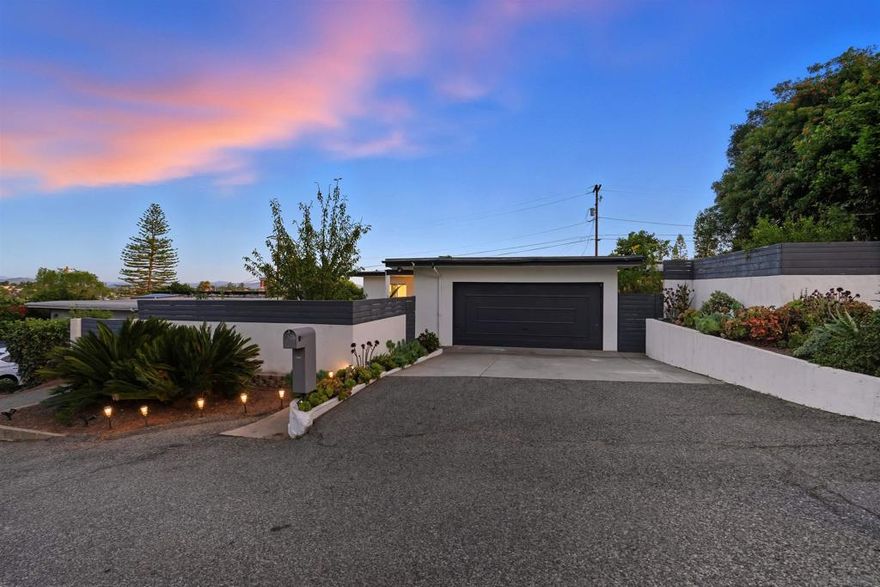 Welcome Home to Mid-Century Magic in Fallbrook! Thank you for stopping by — your dream Mid-Century modern retreat is waiting for you right here in the heart of peaceful Fallbrook! Step inside and be wowed by bold black-and-white tile floors, an open concept layout perfect for gatherings, and a cozy white brick fireplace that practically begs for hot cocoa and good company. The kitchen? Oh, it’s a showstopper — sleek cabinetry, a stylish backsplash, and an island with seating that says, “Yes, invite everyone over.”  The primary suite is your personal spa zone, complete with double sinks and a tiled shower designed to make mornings actually enjoyable. But wait until you head out back — an elevated pool for sunny California days, triangle sail shades with string lights for those “just one more glass of wine” evenings, and plenty of space to laugh, relax, and recharge. And because this home is as smart as it is stylish, you’ll enjoy solar panels that keep your bills low and your eco-karma high. Fallbrook living means serene views, quiet charm, and easy access to everything you need. This isn’t just a house — it’s the lifestyle upgrade you’ve been waiting for.