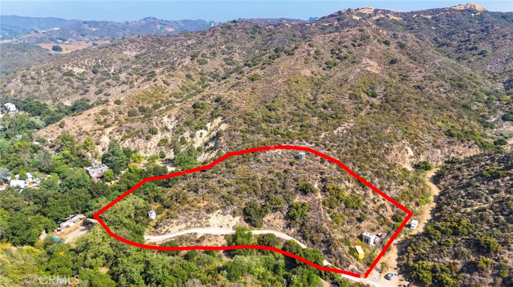 Escape to Your Own Slice of Topanga Tranquility! Tucked away in the scenic Santa Monica Mountains, this 3.5-acre parcel offers sweeping views and lies outside the Coastal Commission zone—making your dream build even more attainable. Imagine crafting your custom retreat with existing resources like an older geology report, percolation test, topography map, architectural plans, and more available upon request. The property includes solar panels, a water storage tank, an accessory structure, a shipping container, and two trailers—all included with the sale.
Set along a partially paved, partially dirt private country road frequented by local equestrians, this peaceful setting feels worlds away yet is just minutes from the heart of Topanga. Enjoy close proximity to the Will Geer Theatricum Botanicum, charming shops, restaurants, schools, the Inn of the Seventh Ray, and Topanga’s stunning beaches.