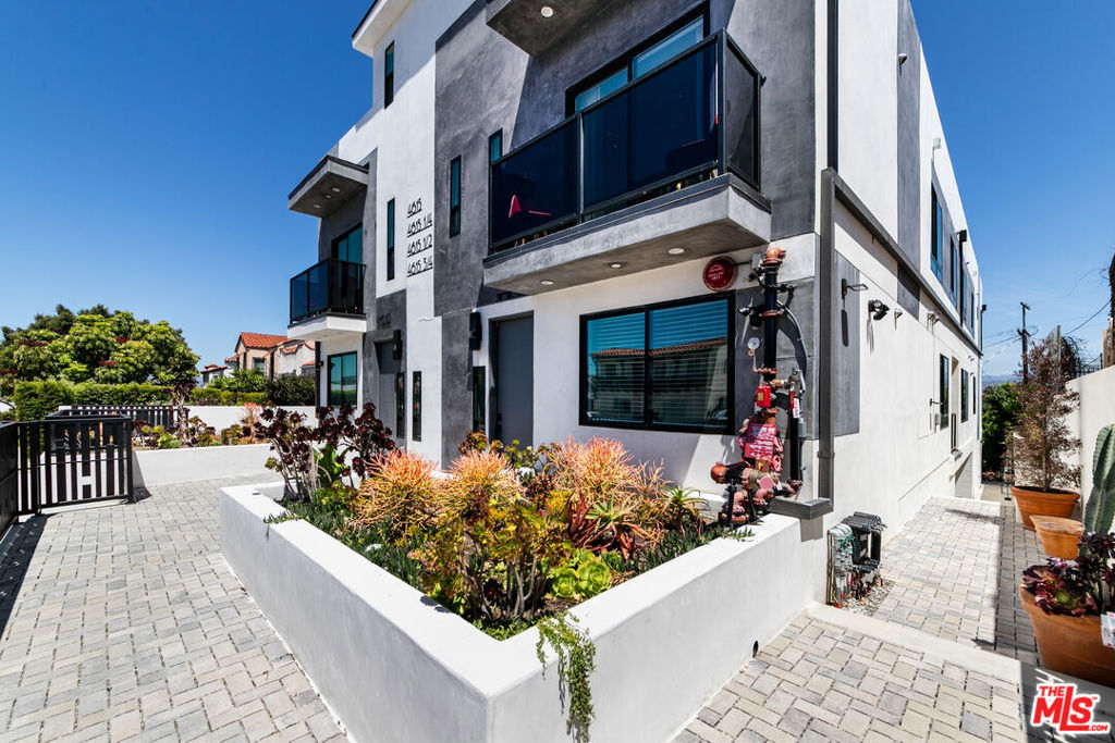 Discover a stunning sanctuary in this newly constructed, design-driven townhouse that exemplifies modern luxury in one of Los Angeles' most dynamic neighborhoods. Nestled in the heart of Mid-City, this contemporary residence offers a perfect blend of refined living, thoughtful design, and sweeping views of the Hollywood Hills including the world-famous Hollywood Sign. Step inside to a spacious, light-filled main level designed for both comfort and style. The chef-inspired kitchen features premium stainless steel appliances, sleek quartz countertops, a statement island with waterfall edge, and custom cabinetry ideal for both everyday cooking and entertaining. The open layout flows effortlessly into the dining and living areas, where expansive windows frame breathtaking hillside views and allow natural light to pour in. Step through large sliding doors to your private balcony an ideal setting for morning routines, quiet reflection, or casual gatherings, all with the beauty of Los Angeles as your backdrop. The main level also includes a generous bedroom and a full modern bathroom, perfect for guests, family, or flexible use as a home office or creative space. Upstairs, you'll find two additional bedrooms with a shared contemporary bathroom, plus a spacious primary suite designed as a personal retreat. The suite features serene hillside views, ample closet space, and a luxurious ensuite bath with dual vanity, designer fixtures, and a large walk-in shower. Throughout the home, custom cabinetry, wide-plank flooring, and high-end finishes speak to the quality and care in every detail. Oversized windows on each level ensure natural light and warmth flow throughout the space all day long. And then there's the true standout: your private rooftop deck, offering incredible panoramic views of the Hollywood Hills and the city skyline. Whether you're hosting a small gathering, enjoying an evening under the stars, or simply unwinding in peace, this space is designed for memorable moments and everyday enjoyment. This beautifully gated property includes secure parking, security cameras, and a quiet sense of privacy all while being minutes from the best of LA: Culver City, The Grove, Beverly Hills, DTLA, museums, restaurants, parks, and shopping destinations. Thoughtfully built, move-in ready, and made for modern living this is not just a home, it's a lifestyle.