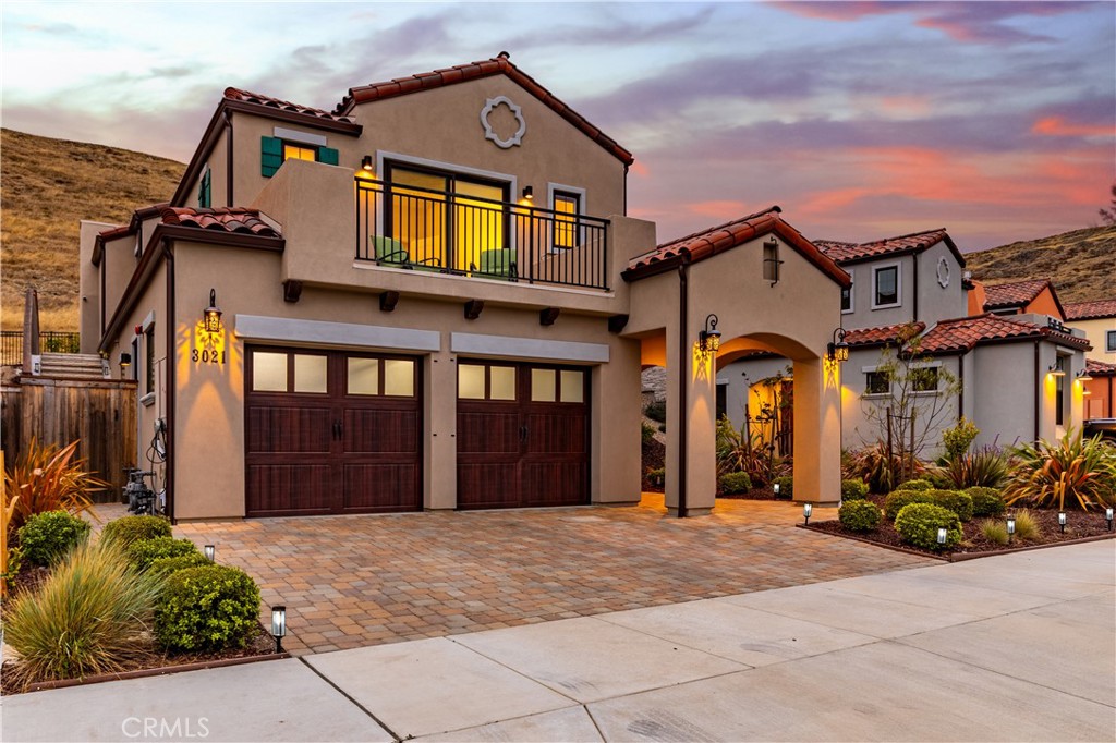 Welcome to 3021 Arezzo Drive, a quintessential Central Coast 1986 sqft home nestled in the sought-after Toscano neighborhood of San Luis Obispo. Built in 2022, this residence showcases contemporary finishes, energy-efficienty and smart home features. The spacious and welcoming first-floor entry boasts 9-foot ceilings and includes the first of two primary suites, complete with an en-suite bathroom and soaking tub. This versatile space is ideal for guests, a home office, or multi-generational living. Upstairs, you'll enjoy an open-concept layout featuring the kitchen, dining, and living room, highlighted by a cozy gas fireplace with hearth. The kitchen is equipped with quartz countertops, a designer backsplash, premium Diamond cabinetry, and high-end appliances. Seamless indoor-outdoor flow leads to a private backyard oasis with pavers, artificial turf, and serene views of the adjacent South Hills Open Space. Second floor also includes a luxurious second primary suite with 10-foot ceilings a south-facing balcony—perfect for unwinding or watching SLO’s iconic sunsets. The en-suite bathroom features a quartz countertop with dual vanity, a spacious curbless tile shower with a frameless glass door, and modern finishes throughout. Additional upstairs amenities include a full laundry room, a third bedroom, and a third bathroom with a second soaking tub. Interior highlights: 8-foot interior doors, Milgard windows, Smooth troweled walls, Recessed lighting, Ample storage, Central air conditioning, Nest thermostat, and Lutron lighting. Exterior highlights: Mediterranean-style tile roof, Paver driveway with additional parking. Attached 2-car garage with tankless water heater. Located just minutes from hiking trails, downtown SLO, the SLO Public Market, Highway 101, local beaches, and renowned wine tasting destinations, this home offers unbeatable access to the best of the Central Coast. It’s a rare find—don’t miss your opportunity