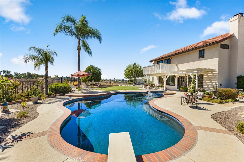 Welcome to 24414 Ranchview Circle in Moreno Valley, located in the highly sought-after Sunnymead Ranch Association. Tucked away in a quiet cul-de-sac, this stunning 4 bedroom, 3 bathroom, 2172 sqft home sits on a premier lot of 9583 sqft overlooking breathtaking mountain and canyon views. From the moment you arrive, the curb appeal shines with low-maintenance landscaping featuring artificial turf, pebble rock, hedges, and greenery that make you feel right at home. Step inside to a grand entryway and an elegant wrought iron staircase that sets the tone. To the right, a spacious living room flows seamlessly into the formal dining area, complete with plantation shutters and updated light fixtures. Just off the side, you’ll discover a charming private courtyard—perfect for your morning coffee, an evening glass of wine, or intimate gatherings. The heart of the home is the open-concept family room and kitchen. The family room offers a cozy fireplace and backyard views, while the remodeled kitchen features modern cabinetry, granite counters, recessed lighting, a breakfast counter, glass cabinet doors, and a walk-in pantry. The breakfast counter and dining nook make this space both functional and inviting. Downstairs also includes a full bedroom and bathroom with shower—ideal for guests or multigenerational living. Upstairs, retreat to the spacious primary suite with crown molding, ceiling fan, and a private balcony showcasing spectacular canyon views. The en-suite bathroom offers dual vanities, an oversized walk-in shower, linen storage, and a generous walk-in closet. Two additional bedrooms with crown molding share a full bathroom, completing the upper level. The backyard is a true entertainer’s paradise, boasting a recently updated pool and spa with pebble finish, multiple seating areas, a grassy play space, and beautiful hardscaping. Whether you’re hosting family gatherings or relaxing under the stars, this space was designed for enjoyment.
Additional features include central air and heating, ceiling fans, recessed lighting, laminate and carpet flooring throughout, a durable tile roof, and a spacious three-car garage. Located in a low tax rate area within the Sunnymead Ranch community, residents also enjoy access to a clubhouse, gym, pool, spa, private lake with fishing, RV parking, parks, and BBQ areas. Conveniently close to schools, shopping, and freeway access, this home truly has it all.