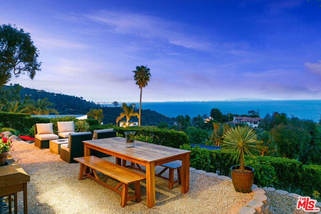 Introducing this exceptional Santa Fe-Contemporary style Malibu retreat with sweeping ocean views and coveted La Costa Beach Club rights. Set on a private 1.57-acre promontory 600 feet above the Pacific with sweeping 270 degree views, this fully gated estate offers a rare convergence of privacy, architectural integrity, and natural beauty. Every detail has been thoughtfully curated to embrace its spectacular setting, with panoramic vistas stretching from Palos Verdes and the Queen's Necklace to Catalina Island, the Santa Monica Pier, and the surrounding canyons. Framed by meticulously landscaped, drought-tolerant gardens and a manicured grassy lawn, the home has been extensively remodeled and combines contemporary living in a peaceful mountain setting. Enter through a dramatic 200-foot driveway to the beautifully designed single-level home, featuring soaring 10- to 16-foot ceilings, clerestory windows, and walls of glass that invite natural light and unfolding ocean views from nearly every room. The open-concept living spaces are anchored by a great room with a newly built slip stone fireplace and custom walnut display shelving, seamlessly flowing into the dining area. French doors open to a backyard oasis featuring a 40' Italian porcelain patio with a pergola, gravel fire pit terrace, al fresco dining area, and a sunken citrus gardenperfect for entertaining. The chef's kitchen boasts Columbia custom cabinetry, a waterfall-edge Pental quartz island with a breakfast bar, and top-of-the-line appliances including a 48" KitchenAid refrigerator, Bosch gas cooktop, Electrolux double ovens, and a Superior wine cabinet. There is an adjoining media room with a built-in 68" flatscreen and exterior access to a barbecue patio. The spacious primary suite enjoys head-on views of the Pacific and sparkling city lights, with direct patio access, a large walk-in closet, and a spa-inspired bath with a double vanity, shower, and soaking tub. There are two additional guest bedrooms with stunning mountain views, including one currently set up as an office. Additional amenities include a Sonos surround sound system, engineered French White Oak flooring, a security system with cameras, a two-car garage with epoxy flooring, and ample parking. Enjoy an exclusive deeded membership to the La Costa Beach Club and tennis courts, offering the ultimate in resort-style Malibu living. The property also includes a deeded road membership with access via a guard-gated private road, providing a direct route to PCH in just minutes. Ideally located in Eastern Malibu with convenient access to Santa Monica and the Westside, beaches, hiking trails, and more. This is a one-of-a-kind property with unparalleled privacy and refined design in an unmatched Malibu setting! There was previously a 1 bed / 1.5 bath detached guest house that was lost in the Palisades fire. House is being sold mostly furnished. Ready for move-in!