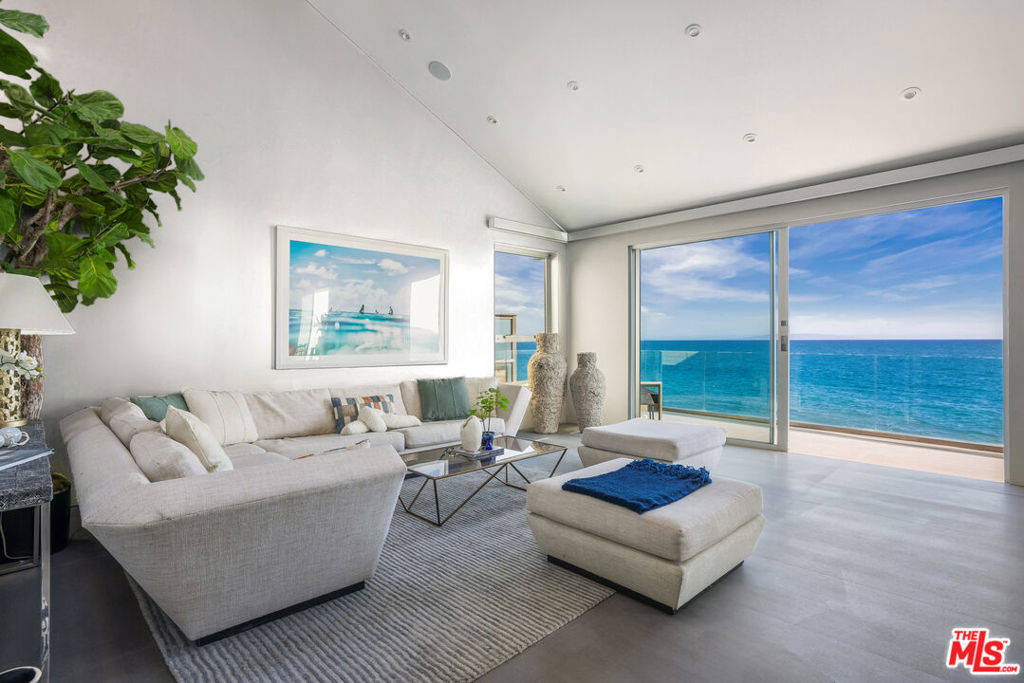 An extraordinary home, sited on a 60-foot-wide lot, you'll be amazed at the sense of spaciousness you feel as you walk through the home. This roomy and luxurious residence commands coastline, island, and ocean views from the Santa Monica Bay to Catalina Island. Gated from Pacific Coast highway, the home's main entrance is tucked away in a private landscaped courtyard, with the large pivoting glass front door offering the first of many stunning sightlines. The main floor is comprised of an open living, dining, and kitchen area with soaring ceilings and absolutely remarkable views from Fleetwood sliding glass doors that open seamlessly to the oceanfront deck and patio. The first of four bedrooms with an en-suite bathroom and the laundry area complete the main floor, along with a powder room. The dramatic double-height living room features a fireplace, gallery walls, and is open to an oceanfront deck. The dining room is open to the deck, where there is additional seating and ample room for entertaining and al fresco dining. The kitchen is between the living room and dining room, with plenty of bar seating, marble countertops, a restaurant quality range and views of the ocean that go on forever. On the upper floor, the additional three en-suite bedrooms include a primary suite that is both elegant and spacious offering a truly inviting retreat. The primary bathroom offers matching slabs of marble, a tub that fills from the ceiling, a rain shower, heated floors, an ocean view shower and contemporary medicine cabinets that open vertically. The residence has many additional features, including an automotive turntable in the garage and parking for 2-3 cars inside the gate. This stunning architectural residence is both contemporary and timeless, a great place from which to enjoy the coastal lifestyle, close to both Santa Monica, Cross Creek, Nobu and all things Malibu.