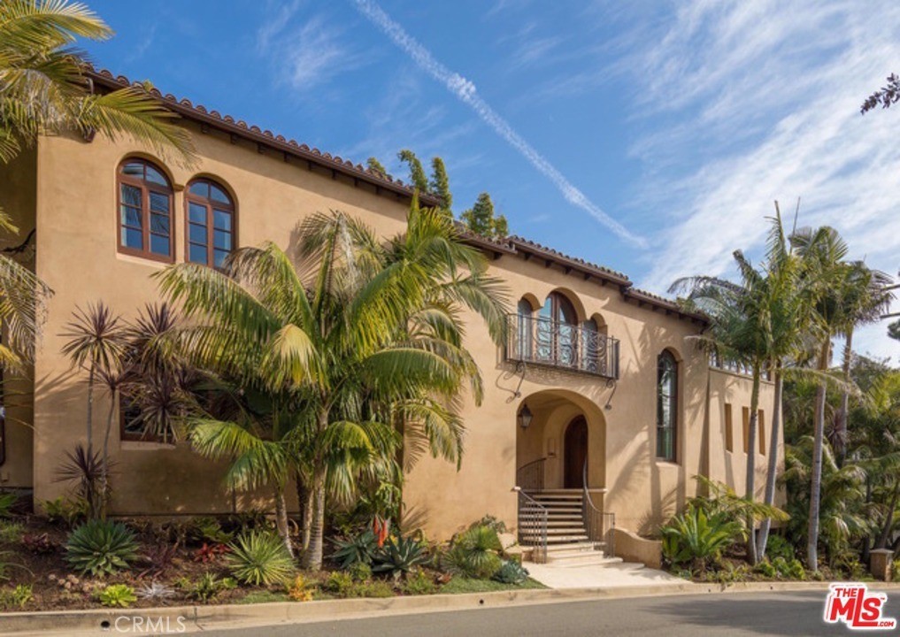 Spanish-style villa in Brentwood offers luxurious living with its authentic architectural details, including barrel ceilings, exposed beams, and arched walnut windows. The home features five oversized bedrooms, with a master suite that boasts a spa-like bathroom, expansive closets, vaulted ceilings, and balconies overlooking a private yard. The chef's kitchen is equipped with customized cabinetry and Viking appliances, perfect for culinary enthusiasts. Outdoors, enjoy a serene backyard with lush landscaping, waterfalls, a lagoon-style pool, barbecue, and fire pit, ideal for entertaining. Located moments from Brentwood's shops and restaurants, this residence epitomizes upscale Westside living