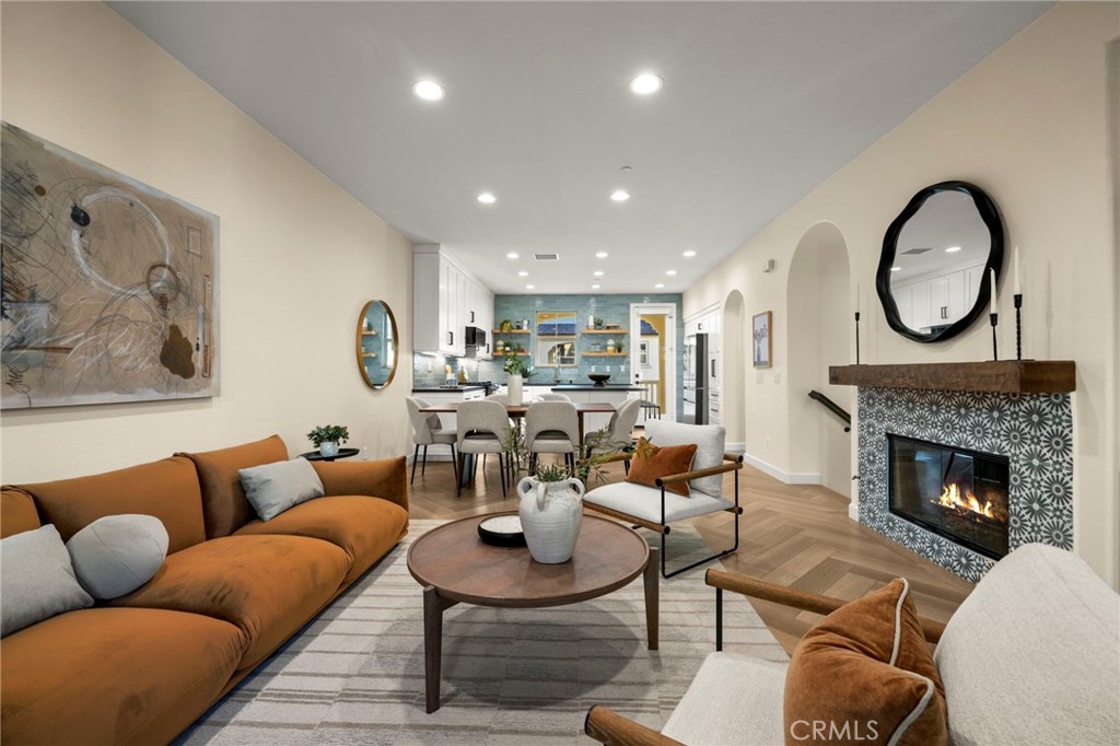 This is the townhouse you've been waiting for in Colony Park...completely renovated, all top of the line appliances included and tucked away in a private location within the community. As soon as you walk in, you're greeted with light oak LVP flooring in a stunning herringbone pattern throughout the home. On the first level, you'll find a bedroom with private keypad entry from the enclosed patio with included mounted TV & attached remodeled 3/4 bath. There is also access to the attached 2-car garage with epoxy flooring, wood storage cabinets, water softener system. The main level (two), you're welcomed into the spacious open floor plan living area brightened by the east/west facing windows. Kitchen is completely remodeled with white shaker cabinets with soft close drawers & doors, corner lazy Susan, pull out drawers in the pantry, stone countertops. expanded island with storage & included smart Samsung appliances. The kitchen leads into the dining area and living room, which is equipped with gas fireplace with tile & wood mantle, wine refrigerator & custom cabinetry, electronic roller shades and access to two balconies, one of which includes a mounted TV. There is also a convenient half bath and laundry room on this level. Head up to level 3 to find your second bedroom with attached full bath as well as the primary retreat. The primary retreat with east facing windows gets the most beautiful morning sun from the oversized windows. Custom cabinetry & bench make the room feel cozy. Head into the primary en suite into a walk-in closet and hotel-like remodeled bath. The dual vanity is designed perfectly with dual sinks, fluted wood shaker cabinets, dimmable lighting and a spa-like shower with vertical wood tile and bench. This home has too many upgrades to list and is a MUST SEE in person. Colony Park’s low association dues include: 3 pools, 2 spas, 3 clubhouses, BBQs, fire pits, security, fitness center, dog park, gorgeous landscaping and a neighborhood park. In addition to all the amenities, it is down the street from the popular Anaheim Packing House and a quick drive to other attractions such as Disneyland, Angel Stadium and the Honda Center.