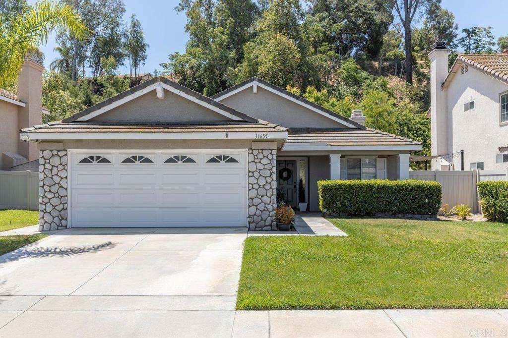 Charming Single-Story Recently Remodeled Home in South Temecula! 3-bedroom, 2-bathroom home nestled against a serene green space, ensuring privacy with no rear neighbors. The spacious 2-car garage offers ample storage for all your needs. Step inside to an inviting open-concept family room featuring vaulted ceilings adorned with recessed lighting, a cozy gas fireplace, and elegant new Tecsun wood laminate flooring throughout. New custom zebra blinds installed 2023. The kitchen has been tastefully remodeled in 2023 with new custom cabinets & hardware, granite countertops with expanded breakfast bar, and modern stainless steel appliances, seamlessly connecting to the dining and family areas—perfect for entertaining! Each room is equipped with new ceiling fans for added comfort. Retreat to the Primary suite, complete with a generous walk-in closet and sliding doors leading to a covered back patio. Remodeled bathrooms with new cabinetry and countertops 2023, along with new tile for the shower enclosure in 2025. Freshly painted walls and baseboards completed in 2022. New HVAC system in 2022. Life Source Water System that requires no maintenance. The backyard is an entertainer's paradise, showcasing stained, stamped concrete, a covered patio, new vinyl fencing, and a private gate granting access to parks, trails, playgrounds, and an exercise course.