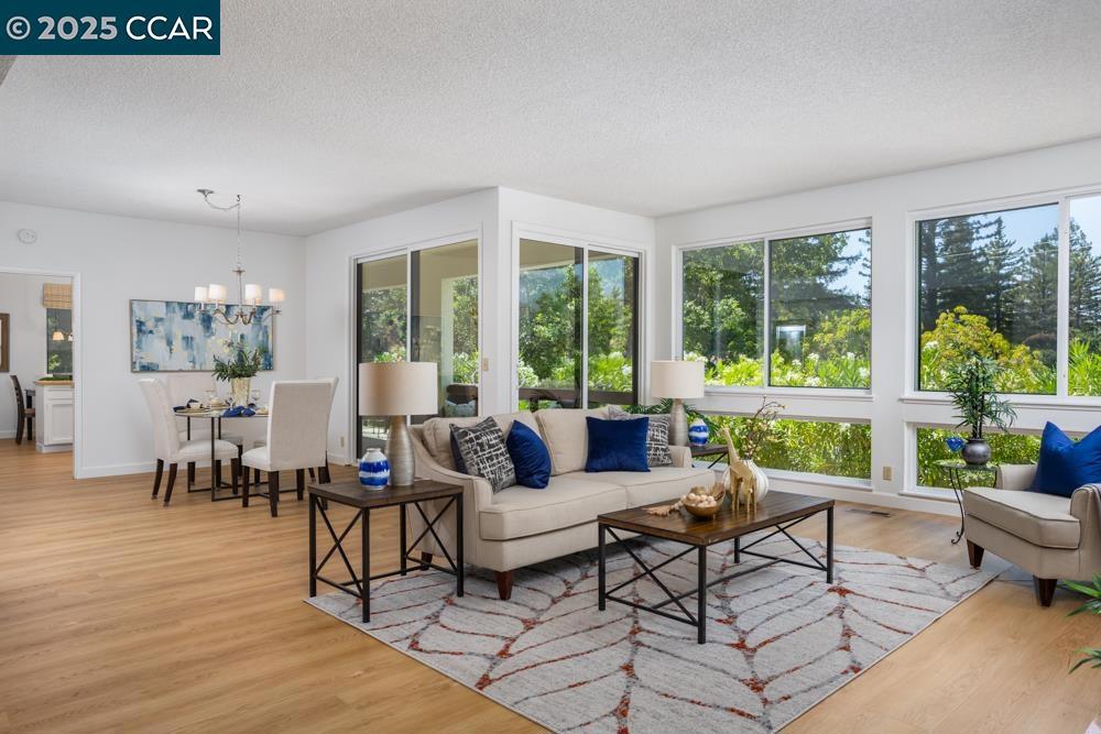 Light-filled and move-in ready! This beautifully updated 2-bedroom, 2-bath home features a flexible den/office, spacious living areas with wood burning fireplace, large windows, and new luxury vinyl plank flooring. Fresh interior paint gives the home a modern, refreshed feel. The convenient eat-in kitchen is perfect for casual dining and everyday living. Step out onto the large deck and enjoy private, tree-lined views—ideal for relaxing or entertaining. Additional highlights include an attached garage with a storage loft and a detached carport for extra parking. A perfect blend of comfort, space, and functionality—don’t miss this one!