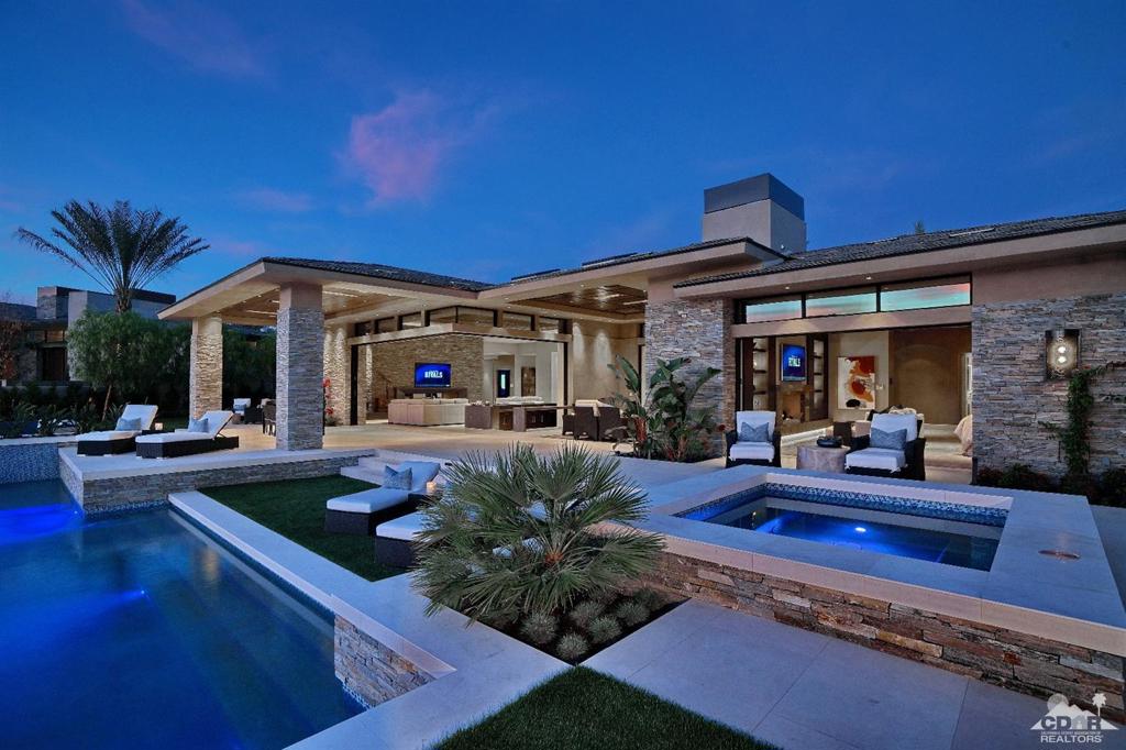 Desert contemporary on a Southwest facing home site at The Madison Club! Private courtyard showcases dramatic fire and water features along with an oversized glass entry door that draws you into this amazing property. This expansive home offers 5 bedrooms, a state-of the art theater, office, wine room and 5.5 baths. Second floor has a separate living area with fireplace, wet bar and 2 well-appointed guest suites. Open floor plan has numerous sliding glass walls allowing a seamless indoor/outdoor transition. Kitchen offers high performance appliances, an oversized island and breakfast bar. Lavish master suite has a fireplace, his and her walk-in closets and spa inspired bathroom. Custom outdoor cook center and living space makes entertaining easy along with an extended patio that surrounds an infinity edge pool and spa. This fully automated home is offered furnished as per inventory.