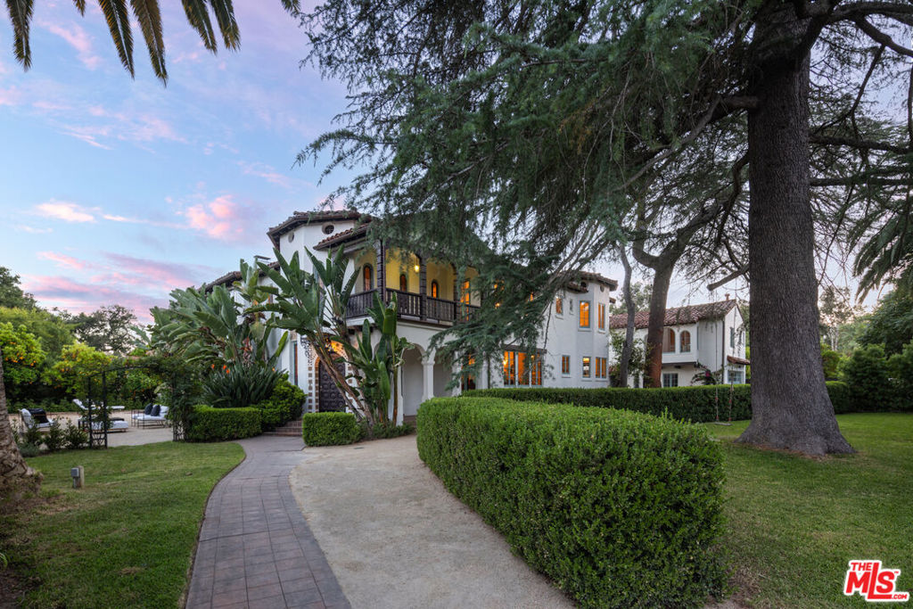 Welcome to The Acacia Mansion, a landmark 1929 Spanish Colonial Revival estate nestled in the heart of Meiners Oaks, Ojai. Situated on an expansive 0.83-acre corner lot, this extraordinary property offers nearly 4,300 square feet of exquisite living space and a rare opportunity to own a piece of Ojai's cultural and architectural legacy.Designated Ventura County Landmark No. 170 and eligible for the Mills Act, this historic residence with Moorish influences and many original details, was originally built for Theosophists David and Madeline Baird, followers of Krishnamurti. Over the years, it has hosted luminaries such as Aldous Huxley, Annie Besant, Marc Chagall. and George Bernard Shaw. Every element of the home reflects its storied past, from the grand pink-marble staircase and hand-carved mahogany doors to gold-leaf ceilings and two original Ernest Batchelder fireplaces. The main residence welcomes you with a breathtaking two-story formal foyer, featuring a filigree wrought-iron staircase, stained glass windows, gold leaf stenciled ceilings, and intricately carved mahogany doors. Elegant formal living and dining rooms, a cozy reading room, and a series of soaring ceilings and arched entryways showcase timeless craftsmanship. Rich hardwood and tile flooring, built-in cabinetry, and graceful balconies with wrought-iron railings evoke the artistry of a bygone era. The chef's kitchen is a culinary delight, outfitted with a La Cornue range, Sub-Zero refrigerator, granite countertops, custom cabinetry, and a walk-in butler's pantry that preserves original architectural details. Upstairs, you'll find five spacious bedrooms and a versatile extra room offering endless possibilities. A detached garage is topped by a private one-bedroom guest apartment with its own entrance- perfect as a secluded retreat or guest quarters. Beyond the interiors, the grounds have been thoughtfully updated and landscaped with mature fruit trees and native drought-tolerant plants. A charming brick patio with an aged fireplace creates a magical setting for gatherings.Recent updates include new HVAC systems, copper gutters, restored exterior plaster, period-style awnings, interior and exterior painting, and enhanced landscaping. The Acacia Mansion is a one-of-a-kind legacy property that offers unmatched character, elegance, and a deep connection to Ojai's spiritual and artistic heritage.