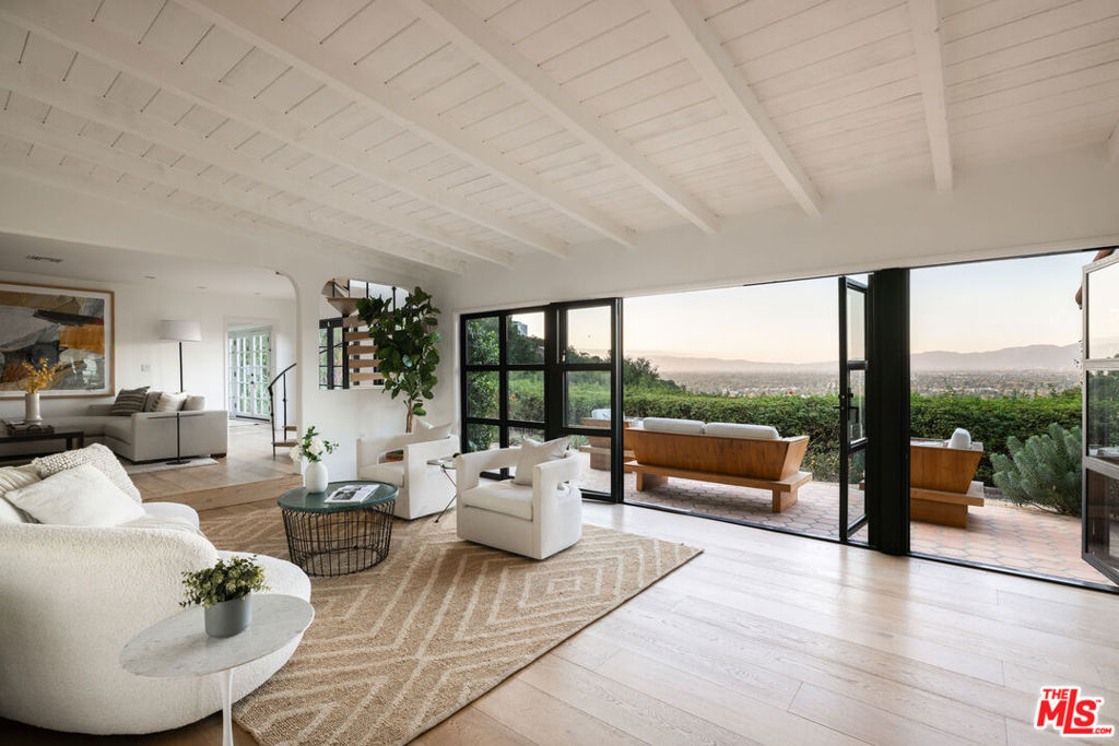 Enchanting hideaway or artist's retreat in the Studio City hills offers complete serenity and sweeping views. Enter through oversized gates and a hidden driveway for absolute privacy and seclusion. Mature hillside landscaping provides natural privacy, shielding the residence and garden from neighboring homes. The grounds feature a Saltillo tiled patio, saltwater pool and spa, outdoor kitchen, multiple seating areas, and fire pit. The 3-bedroom main residence offers a bright, open floor plan, illuminated by nine skylights, with a seamless flow between indoor and outdoor spaces. The living room features beamed ceilings, gas fireplace, French Oak wood floors (throughout), and panoramic views framed by a 20' steel bi-fold curtain wall. An updated kitchen with stainless steel appliances, marble countertops, glass-tiled backsplash, and adjacent breakfast area connects the dining room and outdoor entertaining areas. The ground level is complete with a den, laundry area, powder room, and two bedrooms each with en-suite baths. Upstairs, escape to a magical primary suite appointed with a cozy fireplace, walk-in closet, and full bathroom with dual vanity and a Victoria + Albert soaking tub. The converted garage offers additional air-conditioned living space, providing flexibility for use as a home office, gym, or creative studio. Enjoy additional upgrades like a state-of-the-art water filtration system, home security, raised vegetable garden, dog run with non-toxic AstroTurf, and privacy fencing around the property. Overlooking the esteemed Silver Triangle, the home is moments from some of the best shopping, dining, and entertainment below, yet offers a serene sanctuary you'll be drawn back to time and time again.