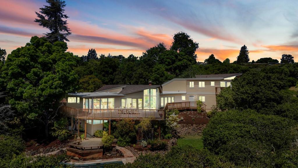 You wake up one morning on the deck of 415 Golden Oak Drive, coffee in hand, gazing at a view that makes time stand still. From this elevated perch in central Portola Valley, the South Bay unfolds rolling hills, morning mist, and the quiet promise of a perfect day. This beautifully updated 4-bedroom, 3.5-bath home offers ~3,700 sq. ft. of refined living space, blending clean architectural lines, natural light, and sweeping sightlines. Set on just under two acres with lawn, pool, mature trees, and expansive decks the property is both functional and breathtaking. Inside, vaulted ceilings and large windows frame the views. The open living and dining areas flow into a thoughtfully designed kitchen with high-end appliances, custom cabinetry, and a spacious island ideal for entertaining or quiet mornings. The ~600 sq. ft. primary suite is a private retreat with a spa-like bath, walk-in closet, and a balcony perfect for stargazing or late-night talks. A separate bonus room with full bath offers flexible space for guests, work, or play. Located in the heart of Portola Valley, minutes from top-rated schools, scenic trails, and local shops, this isn't just a home its a vantage point. A place where space, calm, and style come together. Come for the view. Stay for everything else.