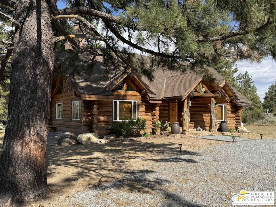 Majestic Mountain Views from this one-of-a-kind Log Home will be a special place for you to call home. Whether used for full-time residency or as a second home, the serenity of this open concept 4.5 acres, is sure to please the most discerning buyer. The Log Home includes a large entry foyer which sets the stage for all the interior spaces of this home. To the left of the entry is the large Great Room with wood burning fireplace, Dining area and Kitchen featuring a whimsical breakfast bar made entirely of a free form log - stunning! The two-story plus high ceilings and the use of the natural log walls lend themselves to the unique character of this special residence. The Great Room is light and bright just perfect for both intimate gatherings or large-scale parties. The views of the mountains in the distance are incredible. The kitchen features granite counters with custom designed backsplashes that depict the mountains - very clever - plus the new electric range/oven, pot-filler and vent hood, double door refrigerator, microwave oven, dishwasher and a semi-hidden pantry closet under the stairs to the loft complete the open kitchen. There is a free form log bar in the corner of the Great Room as well. To the right of the front door is access to the large Primary First Floor Suite with extremely high ceilings and a ceiling fan and access to the combination dressing room/spa room and then on to the primary ensuite bath. The stall shower has beautiful stone work. The double vanity, with granite counters, is great as well. The views from the bathroom and primary suite are exquisite, as they are from the other rooms in this well designed home. The dressing/spa room offers direct access to the north facing deck with room for outdoor entertaining and the outdoor spa, just a few steps away. At the other end of the home, the French doors off the Great Room lead to the first floor bedroom, which could also be used as an office or study. This room also offers access to the north facing deck. Besides the first floor bathroom - with the stackable laundry closet - up the stairs is the additional lofted bedroom - extremely light and bright featuring lovely views to the north. The property is well maintained with pastures for a myriad of uses and the electronically operated iron gate sets the stage for what awaits owners and visitors to this massive property. Located within a 45 minute drive to Palm Desert - El Paseo - shopping and dining and the property is about a 25 minute drive to Idyllwild/Pine Cove. The Paradise Valley Cafe, at the corner of Hwy 371 and Hwy 74 is a great dining location just a few miles to the east of the property. The community has it's own clubhouse known as the Garner Valley Property Owners Association also located on Devils Ladder Road. Easy to show. Welcome to your new Mountain Home!
