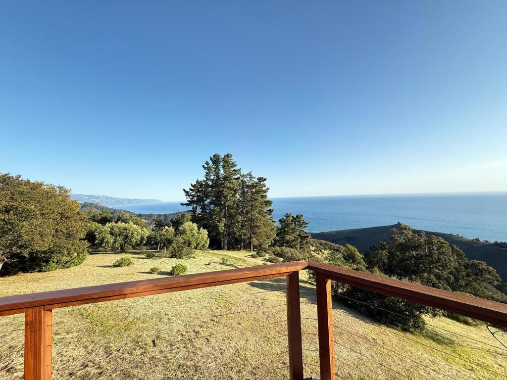 This is the property which Big Sur's original legendary realtor, Hank Adams, who knew the properties of Big Sur like no other for decades, called his home. Located just above one of the most beautiful beaches on the planet (Pfeiffer Beach), this property's 20 acres sit on Clear Ridge at precisely the height which offers panoramic views of the Santa Lucia coastal mountain range and it's sunrises, the south coast's meeting with the ocean as far as one can see, and west to the Pacific's horizon and it's glorious sunsets. It is here that one finds a remarkably wide and gently sloped ridge top series of old growth oak studded meadows, if you will, from which those views become even more spectacular. It was in the very center of this setting that Hank chose to build the wood and glass home which he called Teapot. Inside, a wood burning stove with a wall of windows behind it anchors the living room and kitchen, with multiple sliding glass doors opening to the wraparound deck. The master bedroom features ocean views, and a beloved outdoor shower, should one prefer it to the two interior bathrooms. This humble Shangri La is ready to be enjoyed now, but also is a perfect candidate for a new owner to design and build their dream home that takes Hank's Teapot dream to the next level.