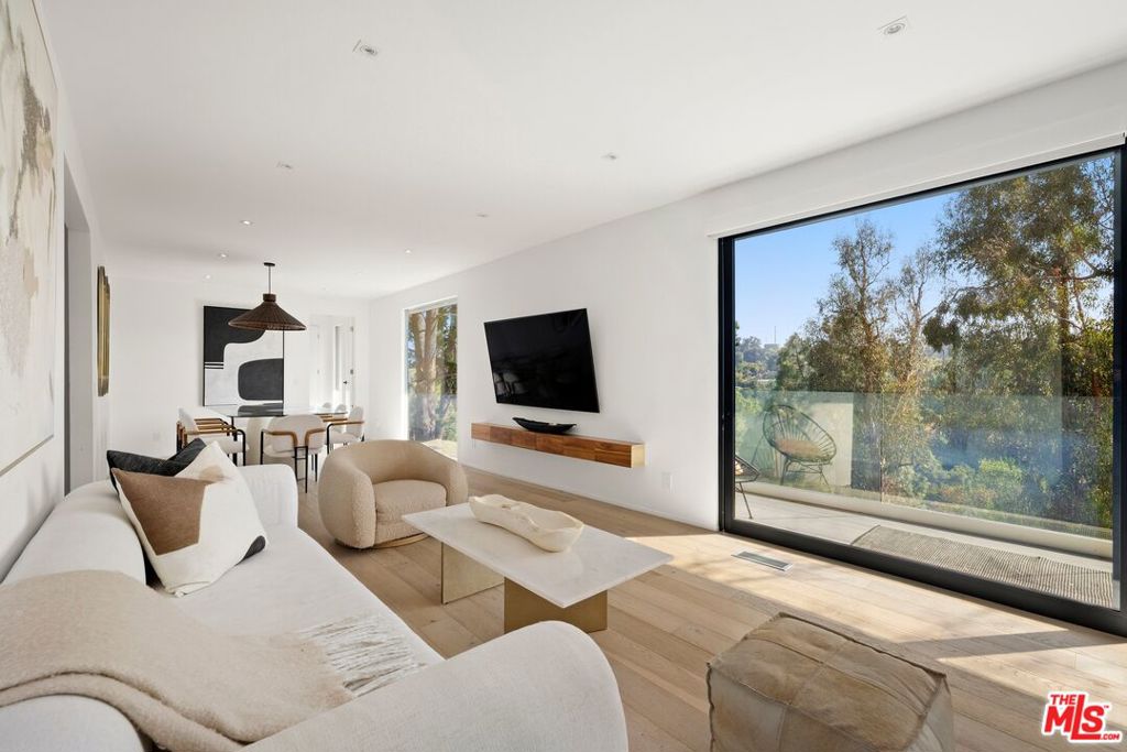 Welcome to this beautifully renovated Hollywood Hills West refuge positioned on a non-through street with sweeping views of the canyon, trees, and hills. Enter through a secured gate to the home's private front patio, the perfect place to enjoy a morning beverage, barbecue, or converse with guests. Inside, discover a fully updated kitchen with custom cabinetry, top-of-the-line appliances, and center waterfall island. Wood floors flow into the living room, complete with large panes of sliding glass that open to the main-level balcony and its spectacular vistas. Nearby, the dining room also promises serene views through a large picture window. On the lower level, the owner's wing includes a makeup nook, sitting area, and direct access to an expansive viewing deck with numerous sitting and lounging areas. The spa-inspired bath features a floating dual-sink vanity, soaking tub, large picture window, and oversized rainwater shower. Custom built-ins in the walk-in closet maximize use of space. There is also a bonus room that can be used as an office, gym, yoga studio, media room, writer's haven, and more. Outside, a nature pathway leads to the terraced gardens below, ideal for peaceful meditation and thoughtful solitude. For added convenience, there is a massive amount of storage space in both the attic and basement, with each measuring roughly 900 square feet in size! Enjoy this central location tucked away from the city yet just moments to Laurel Canyon's cult favorite Pace restaurant, Sunset Boulevard, the Westside, Mulholland Drive, and the Valley. Top-rated Wonderland Avenue Elementary School and Mulholland Tennis Club are also close by.