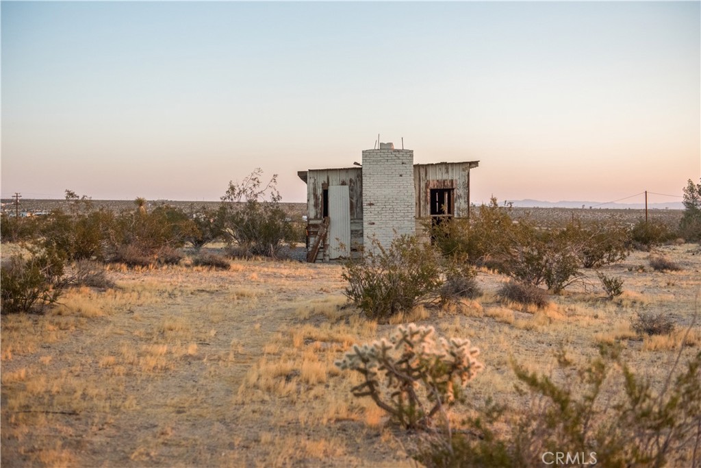 Perched on a gently elevated 5-acre mesa in North Joshua Tree’s Hidden Rivers area, this vintage recreational homestead cabin offers panoramic views of sunrise, sunset, moonrise, and moonset—with just one Joshua Tree on site, allowing for more flexibility when planning updates or expansion.
The property has legal access, residential zoning (RES | RES ZONE MAX 14 UTS & USE EX HPC/MHM), and power and water in the street, providing a solid foundation for your vision.
The presence of an original, permitted recreational cabin is a major advantage. In San Bernardino County, recreational cabins are considered legal structures intended for occasional or seasonal use—not for full-time occupancy. But because this structure already exists, you may be eligible to apply for an alteration permit rather than starting from scratch with new construction. That can streamline the permitting process and reduce costs, making it much more feasible to convert the cabin into a permitted single-family residence by adding a kitchen and bath and bringing it up to code.
Of course, if your vision is to simply restore the cabin and enjoy it as a historic off-grid retreat, that's also a valid and valuable path. The conceptual renderings we developed explore both possibilities—whether you're looking to preserve the desert heritage or transform the site into a modern retreat with minimal intervention.
Just a short drive to downtown Joshua Tree, yet with a remote and serene feel, this property invites you to walk the land, feel the stillness, and imagine what’s next.
APN: 0599-311-04
