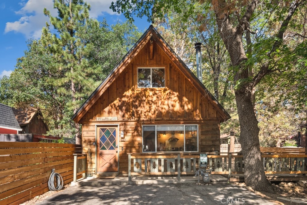 Charming Sugarloaf Cabin Chalet on a Spacious Lot. Tucked among towering pines, this charming Sugarloaf chalet-style cabin offers rustic elegance with modern comforts. Sitting on an expansive fully fenced and gated lot, the home features a large parking pad, spacious deck, and a cozy firepit area—perfect for relaxing, BBQs, and year-round enjoyment. Go inside to soaring vaulted pine and beamed ceilings, an open floorplan, and a welcoming living room with a high-efficiency wood stove. The updated kitchen shines with butcher block countertops, stainless steel appliances, peninsula bar seating, and open shelving, making entertaining easy and stylish. The main level includes a bedroom and a beautifully updated bathroom featuring heated tile floors, a natural stone vessel sink, and a custom vanity. Upstairs, a spacious loft-style bedroom offers additional comfort and charm. Flooring includes durable wood-look tile and carpeted bedrooms. Enjoy peace of mind with upgrades like a newer insulated roof (2016) and dual-pane windows. A storage shed, patio, and ample outdoor space complete this mountain getaway. Ideally located just minutes from Kallan’s Bar & Grill, the general store, local parks, and schools—this home is ready for your next adventure or full-time mountain living.