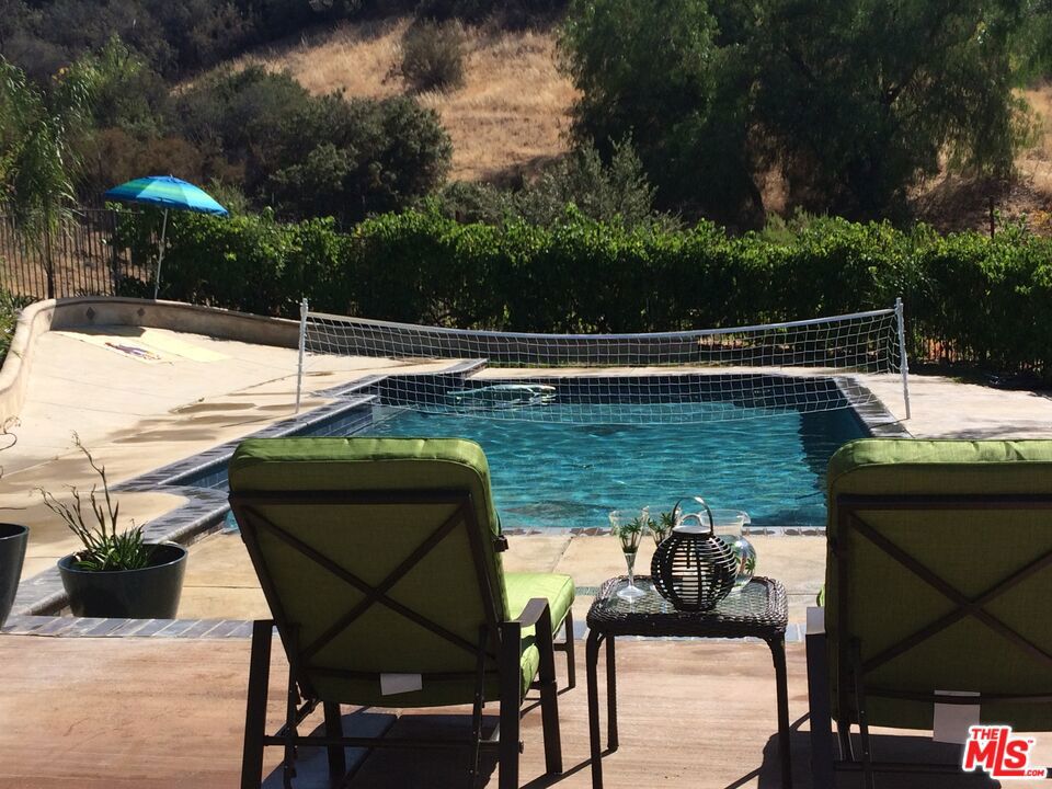 FULLY-FURNISHED, FULLY-EQUIPPED. AVAILABLE FOR SHORT AND LONG STAYS. Call for availability. Easy access to the property - no narrow or windy canyon roads to navigate, just minutes to Malibu or the 101 freeway! No steep cliffs or canyons surrounding the house! Property sits on 4 usable acres. Private office can be 5th bedroom. Fabulous gated retreat situated in Malibu Wine Country and adjacent to walking, hiking or biking trails, and zoned for horses! Enjoy privacy and serenity, surrounded by nature. The entire property is fenced, with multiple separate large fenced areas and automatic entry gates. Drive down long tree-lined private driveway to the house, which is not visible from the street- truly private. Plenty of parking space for guests, RV parking and hook-ups, electric car charger in garage. The custom home features expansive views and landscaped grounds with lawns, grape vines and dozens of mature fruit trees. Large front meadow suitable for sports and games, and patio areas for outdoor entertaining. A sparkling party pool with pebble plaster. Many recent upgrades -new roof, high efficiency heaters and AC units, tankless water heater, new carpet. Expansive floor to ceiling windows and glass doors and skylights. Beautiful formal library with custom wood, separate private office with wet bar, hardwood floors, stone floors and new carpet upstairs. Large bedrooms, each with walk-in closet and room darkening window coverings. The master suite balcony view of the private park-like grounds. Chef's kitchen with Viking appliances. Well water for irrigation is a significant saving on utility bills. Prized Las Virgenes school district is one of California's top rated school districts. Nothing else compares at this price! You will not find another private retreat in the price range!