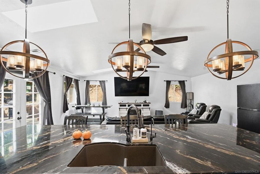 Love to cook or entertain? You’ll fall for this Santee home’s dream kitchen! Located in the desirable West End, this 3-bedroom, 2-bath home offers 1,507 sq. ft. of comfortable living. Step inside to a spacious formal dining area that could double as a sitting area, playroom, or home office, a perfect flex space for any lifestyle.  The home features a large family/great room with multiple skylights that bring in beautiful natural light, an attached 2-car garage, RV parking with full hook-ups, 220V outlet in the front yard for EV charging, French drains installed in the front yard, low-maintenance landscaping, and a dedicated dog run with turf.  The remodeled kitchen is the showpiece, featuring a 5-burner gas cooktop, custom vent hood, and pot filler, plus an oversized black and gold granite island and a high-end microwave/oven combo with convection and air fryer functions, perfect for the home chef!  Upgrades include a new roof (Aug 2024) and leased solar with 24 panels (approx. $250/month; buyout available). Additional features include an alkaline water filter, water softener, and a Clean Start laundry system that allows you to sanitize clothes without harsh detergents.  Close to parks, schools, Cowles Mountain, Mission Trails, and the Santee Shopping Center with restaurants and retail.  VA/FHA welcome!