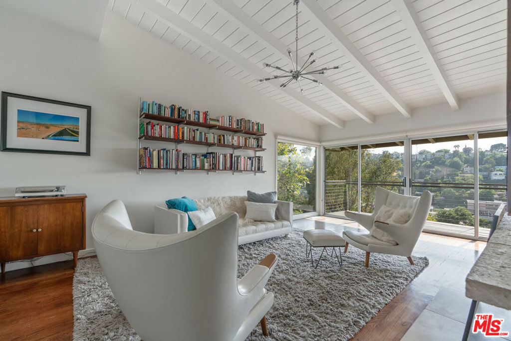 Perched high in the coveted Moreno Highlands of Silver Lake, the 1958 Koepke House is a mid century gem designed by architect E. Ralph McSwan. This rare post-and-beam home showcases the hallmarks of mid-century design - clean lines, soaring ceilings, and expansive glass, while offering breathtaking views of Downtown Los Angeles and the Griffith Park Observatory. With 4 bedrooms, 2.5 bathrooms, and a versatile floor plan across two levels, the home is both elegant and highly functional. The main level features dramatic vaulted ceilings, open-concept living and dining areas anchored by a striking free-standing fossil stone fireplace plus seamless indoor-outdoor flow to balconies accessible from every room. A sleek, modern kitchen and powder room sit just off the dining area, while the spacious primary suite includes its own fireplace and walk in closet. The lower level opens to a large den/media room with its original fireplace and direct access to a second expansive deck. Two additional bedrooms, a full hall bath, and an office (or additional bedroom) complete with private street entrance offer the perfect blend of privacy and flexibility for work-from-home or guest accommodations. The attached garage provides parking for 2 cars. Thoughtfully sited to maximize privacy and views, this is a unique opportunity to live in a piece of architectural history just moments away from the reservoir and all the great dining and shopping Silver Lake has to offer. Available for occupancy in late August, fully furnished.