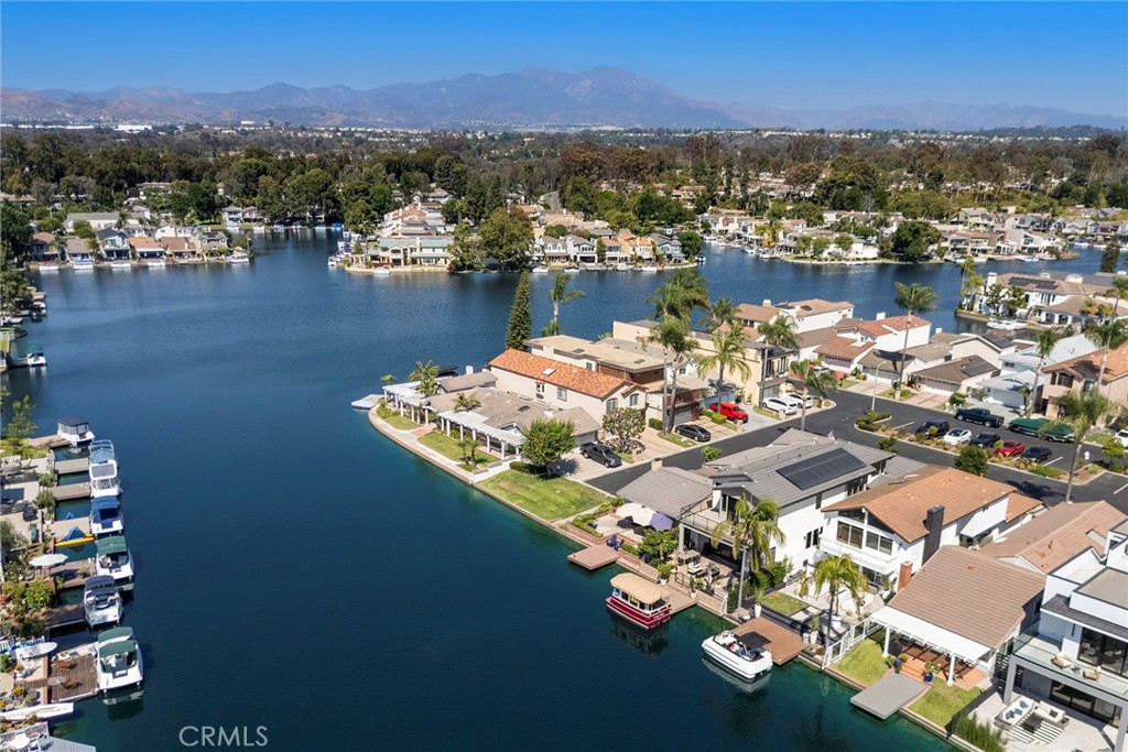 Experience refined lakeside living at its finest in this exquisitely remodeled 4 bedroom 3 bathroom home located in the highly coveted Lake Forest Keys community, offering a prime waterfront setting with a private dock for your boat. Every detail of this residence has been thoughtfully curated in 2024 to blend modern luxury with timeless elegance. Inside, rich wood flooring flows seamlessly throughout, complementing the striking remodeled staircase and sophisticated recessed and designer lighting. Expansive new windows, doors, and a family room slider frame picturesque lake views, while updated fireplaces in both the family and primary room add warmth and style. The fully reimagined kitchen is a culinary masterpiece showcasing custom soft-close cabinetry, a 15-foot Cambria Ella luxury quartz island with designer pendants, and premium appliances including a Dacor refrigerator and freezer, Gaggenau electric cooktop, oven and warmer, and Cove dishwasher. The upstairs primary suite is a private retreat offering a spa-inspired bathroom with Kallista bathtub, Porcelanosa tile, a custom vanity, touchscreen steam control mirrors, skylight, and a modern Kohler toilet. The guest bath mirrors this sophistication with Porcelanosa finishes, Kallista shower heads, custom vanity, and steam control mirrors, while the powder room is a showpiece with its custom wall-hung sink and premium fixtures. The home has been fully repiped, outfitted with a new electrical panel and re-wire, new ducts and HVAC system, smart outlets, and all new switches and outlets for comfort and convenience. The laundry room has been relocated upstairs for efficiency, and the garage offers new cabinetry, drywall, lighting, frosted windows, epoxy flooring, attic storage with ladder, and a MyQ garage system. Outdoors, lush new landscaping, and lighting, set the stage for relaxed entertaining, and a brand new dock invites you to enjoy peaceful sunsets and leisurely days on the water. This exceptional property combines modern innovation, luxurious finishes, and an unrivaled lakefront setting within the Lake Forest Keys to deliver the ultimate Southern California lifestyle.