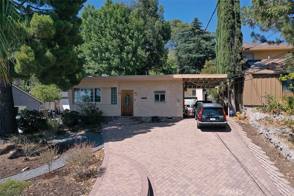 Opportunity to own a move in condition 3 bedroom 2 bath house on a large rectangular lot with existing guest house and almost level pad at rear suitable to build an ADU. The house is well maintained and has hardwood floors throughout with central air conditioning and two fireplaces plus a wood burning stove in the rear bedroom. There is a separate guest house with bathroom that is presently used for storage. The rear portion of this lot has a large almost level pad with no structure and is suitable to build an ADU. There is an attached carport and plenty of parking in the driveway. Nestled at the base of foothills this neighborhood is residential and readily accessible to shopping, dining and the 210 freeway.