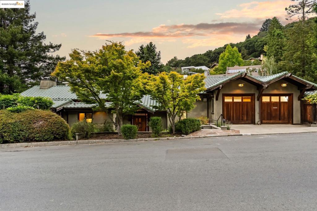Experience 3,148 square feet of exquisite craftsmanship in this custom-built Claremont Hills home, designed by architect Tom Dinwoodie and built in 1995. Nestled in a lush, creekside setting, this architectural gem blends timeless design with storybook charm—soaring wood-beamed ceilings, grand panel windows, and vibrant gardens create an enchanting retreat. Inside, the spacious layout includes three en-suite bedrooms, elegant living and dining rooms with a fireplace and built-in seating, a family room with custom shelving, a dedicated office with built-ins, and even a darkroom for photography enthusiasts. The inviting country kitchen features a cozy breakfast nook that opens to a garden blooming with wisteria, fig, and lemon trees. Relax in the in-ground soaking tub as the sound of the creek and rustling trees soothe you. Just moments from the Claremont Resort & Spa, this peaceful and majestic home offers the perfect balance of nature and convenience.