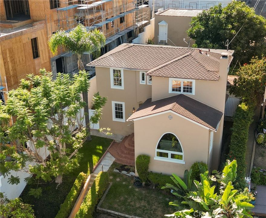 Perched high above the street, this timeless 1937 Spanish-style home captures sweeping views of the Los Angeles Harbor and the iconic Vincent Thomas Bridge. Arched windows and classic architectural details set the tone, while original hardwood floors add warmth and character throughout. The spacious living room features coved ceilings, and a striking wood burning fireplace with an oak mantle and stone facing as its centerpiece. Many windows bathe the space in bountiful sunlight and harbor views can be seem from almost every room in the house! With over 1,700 square feet, the floor plan is both generous and functional. The large formal dining room flows into a beautifully remodeled kitchen, appointed with hickory cabinets, granite countertops, stainless steel appliances (including a French door refrigerator), and a convenient wet bar/prep sink. A built-in office nook and a garden window overlooking the lush backyard add both style and utility, while the adjacent laundry room provides even more storage and pantry space. An updated ¾ bath completes the first level. As you make your way up the winding staircase with its original iron railing, you’ll find two spacious bedrooms – one with dual closets, including a walk-in! There is also an updated full bathroom. A versatile bonus room (perfect for a nursery, office or creative space) opens to a shaded veranda overlooking the backyard. The backyard is a true retreat—boasting a mature avocado tree heavy with fruit, a wide grassy area, a large entertaining deck, and a Tuff Shed for extra storage. Alley access to a two-car garage completes the property.  Over time, this property has been updated with dual pane windows, newer FAU, water heater (2021), and even drain and sewer line upgrades. There is added storage in the (easily accessible) basement…or maybe even a potential wine cellar! Surrounding new construction can only increase your home's value! This property is well located close to everything you need, and not far to the Marina, Cabrillo Beach and several parks. The main attraction is the upcoming West Harbor waterfront, with new restaurants, shops, an amphitheater and even a Ferris Wheel! This home blends historic charm with thoughtful updates, all in a hillside setting with amazing harbor views. ***THIS PROPERTY QUALIFIES FOR A $20,000 COMMUNITY GRANT PROGRAM THROUGH CITIBANK'S LADDER-UP PROGRAM***