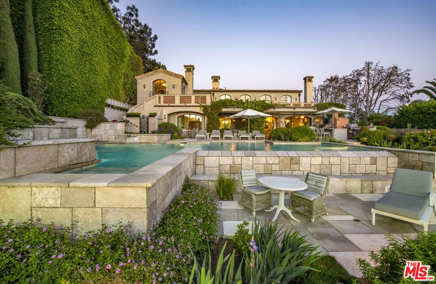 Introducing Villa di Vita Bella, an architectural triumph of timeless design by esteemed architect Douglas W. Burdge, AIA, set within Malibu's most secluded enclave, the 24-hour security-bound Serra Retreat. Beyond its own gates, this peninsula estate commands extraordinary privacy and one of the rarest vantage points in Southern California: the ability to watch the sun rise over the ocean from the front of the home and set into the sea from the back. Resting on more than an acre of terraced Italianate gardens, the residence unfolds as a sprawling private resort, with an infinity pool and spa, championship tennis court, Kalamazoo outdoor kitchen, and fitness pavilion. Every element has been crafted with uncompromising artistry and imported European materials, blending old-world sophistication with California's coastal ease. Inside, soaring interiors showcase Venetian plaster walls, a grand double-height foyer with a sweeping marble staircase, and curated spaces designed for both intimate living and lavish entertaining. The La Cornue chef's kitchen is complemented by a bespoke butler's pantry, while the primary retreat offers a sanctuary with a couture closet, wraparound terrace, and a spa-inspired bath featuring silver-plated sink basins, a sculptural marble tub, and a coastline-view steam shower. Entertainment abounds on the lower level with a theater, 800-bottle temperature-controlled wine cellar, and recreation lounge that flows seamlessly outdoors to a patio adorned with a hand-painted mural by artist James Goldcrown. A detached guest house mirrors the estate's refined aesthetic, complete with its own La Cornue kitchen, living room, fireplace, and terraces with awe-inspiring sunset vistas--ideal for hosting extended stays with comfort and style. Marrying its European pedigree with modern innovation, Villa di Vita Bella is equipped with advanced home tech, including Crestron home automation, radiant heated floors, central vacuum, water purification, and a state-of-the-art Generac generator. Its coveted location ensures not only tranquility but also proximity to Malibu's world-class beaches, Nobu, Soho House, and the Malibu Country Mart. A rare fusion of privacy, prestige, and permanence, Villa di Vita Bella stands as a once-in-a-lifetime opportunity to own one of Malibu's most breathtaking ocean view estates.