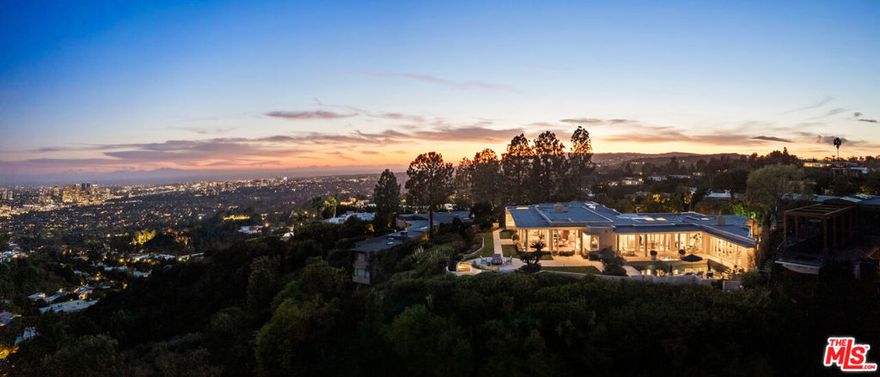 Tucked away on one of Trousdale Estate's most prestigious streets, this stunning Contemporary Mediterranean residence offers the BEST city and ocean views, luxurious finishes, and masterful design. Set on a sprawling 43,000-square-foot lot, the estate welcomes guests with lush landscaping, a grand gated entry, and an expansive motor court. Designed for both grand entertaining and everyday elegance, the open floor plan features soaring ceilings and floor-to-ceiling glass walls that capture the stunning vistas. The gourmet kitchen seamlessly flows into the family room and breakfast area, all overlooking the resort-style pool and spa. The primary suite is a private sanctuary with dual spa-like baths and expansive walk-in closets. Seven additional guest suites, a formal dining room, and a grand living area with a wet bar add to the home's impressive scale. Outdoors, the estate offers multiple al fresco dining spaces, a fully equipped outdoor kitchen, and a spectacular pool and spa with sweeping views of the Los Angeles skyline. Blending sophistication with warmth, this one-of-a-kind residence is designed to inspire and impress.