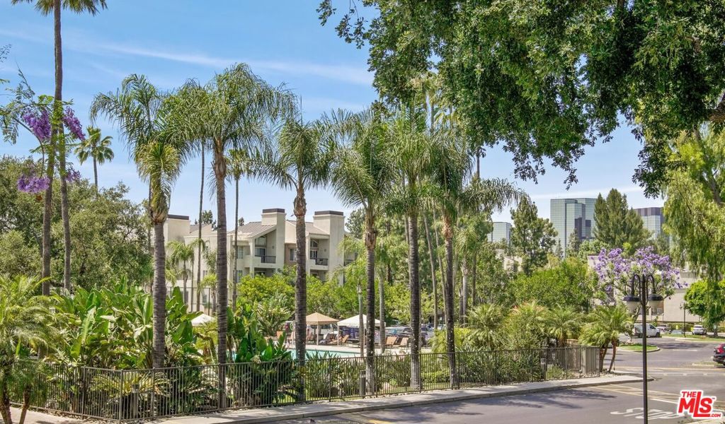 Welcome to The Met at Warner Center, this vibrant resort style community features multiple swimming pools, fitness center, tennis courts, indoor basketball court, indoor racquet ball, children's playground, onsite HOA, visitor parking, and 24- hour guard gated access. Step into this desirable single-story condo featuring a highly sought-after split floor plan with two primary suites positioned on opposite sides of the living room. The galley kitchen is outfitted with stainless steel appliances and granite countertops with an open layout that flows to the living room making it ideal for socializing with guests and family. Highlights include crown molding, tile flooring, recessed lighting, and a cozy gas fireplace. Slide open the living room doors to access a long private balcony, ideal for relaxing, gardening, or setting up a charming cafe-style seating area where you can enjoy views of the main clubhouse and sparkling pool. Enjoy the convenience of In-unit laundry with front-loading washer and dryer, custom closets for stylish efficient storage, central A/C and heating, and two assigned parking spaces in a secure garage. HOA includes: trash, water, guard gate, maintenance/landscaping for common areas, exterior building and earthquake insurance. You will find this location is centrally located to Warner Center, The Village, Westfield Topanga, Costco, Movie Theatres, Warner Park, Fallbrook Mall, Grocery Markets, Entertainment, Restaurants, and easy access to the 101 freeway.