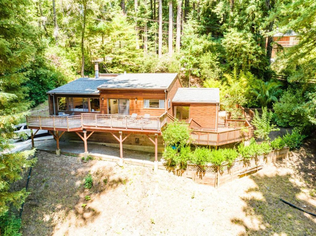 Peaceful home in the redwoods, located in the wonderful Ridgeview Estates neighborhood. Well built home with vaulted wood ceilings in the living room, fireplace, wide entry and hallway, wainscoting trim. Mostly single-level layout with just a few steps down to the primary bedroom. The spacious kitchen has a large island with dining bar and an adjoining dining area with coffered ceiling. Huge deck off the kitchen with views of the trees and mountains, an ideal spot to unwind. The primary suite has a slider to a deck, a large bathroom with oversized tub and double sinks. The 2-car garage has a bonus workshop area. Private and quiet setting and a good commute location, only about 30 minutes to Saratoga. Dependable Xfinity internet available.