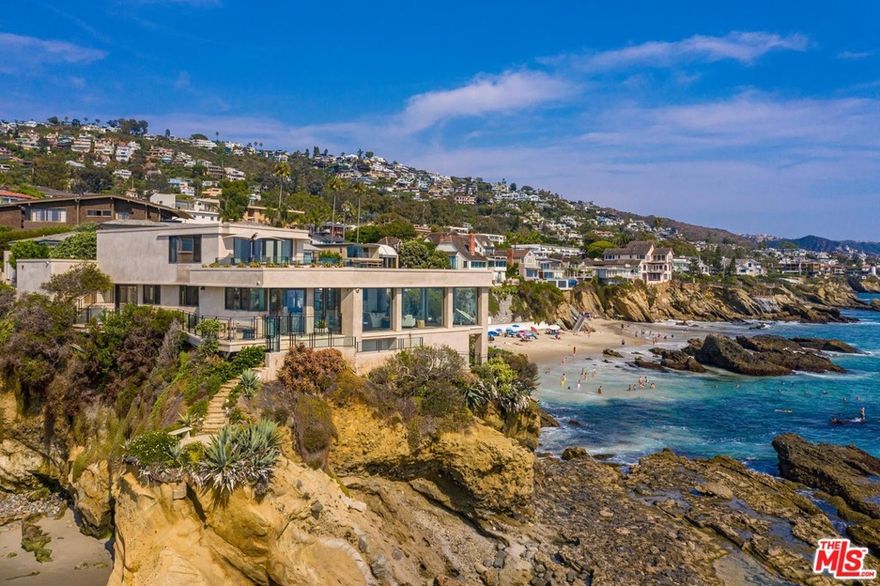 Extraordinary opportunity to live above Arch Rock with stunning Pacific Ocean and sunset views. Nestled between Pearl St and Woods Cove Beach, this gorgeous estate is suspended at the water's edge with unmatched ocean, island, and coastline views. Wrapped in floor-to-ceiling glass this architectural gem takes full advantage of the dramatic 270-degree panoramic views. This home has expansive entertaining rooms all opening through disappearing walls to broad limestone terraces set above the crashing surf. The owner's suite is spectacular with a private terrace featuring views up and down the coastline. Also included are a waterfront great room, an oversized dining room, two guest suites (one detached for privacy), a chef's kitchen, an informal dining area, and five large waterside terraces. All of this is set behind a private gate, with a private motor court, hidden from street view. A private path to the beach has a scenic overlook set just above the beach and tide pools.