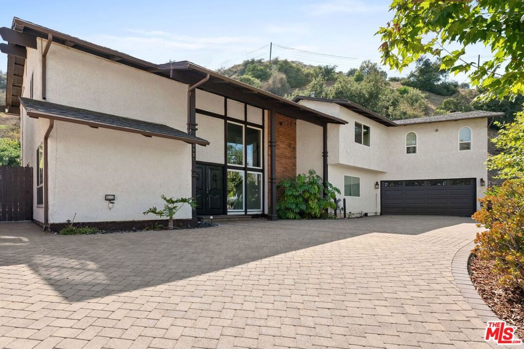 Nestled on a quiet cul-de-sac in the picturesque Santa Monica mountains, this 5 bed 4 bath pool home on over 1/2 an acre offers a harmonious blend of modern luxury and natural tranquility. From every window you can see nature! Indoor-outdoor California living is maximized in this home, the living area seamlessly opens up into the resort-like backyard which is a true entertainer's dream with pool, gazebo and bar that has windows that open into the kitchen! You can already imagine your house-warming party here! For moments of solitude, a private grassy nook offers an ideal space for meditation and relaxation.This expansive home spans 3,256 square feet set on a generous 26,042 square foot lot. True privacy awaits. Upon entering, you are greeted by a tastefully remodeled interior adorned with gorgeous wood laminate flooring and Italian tile, perfectly complemented in the kitchen by high-end Jenn-Air appliances and designer light fixtures. The two large master suites are a true highlight, with one boasting a cozy fireplace, a private balcony, and a newly-built custom walk-in closet. Another highlight are solar panels that were installed in 2022 and are completely paid off. Also, a completely replastered and remodeleled and retiled pool, and there is a new gazebo in the backyard perfect for your al fresco dining. In addition, new central air and heat installed in 2020. Located in the serene Woodland Crest, this home provides the perfect retreat for those who appreciate nature yet desire the comforts of city life, being just a short distance from the amenities of Ventura Blvd, Topanga and the 101 freeway. This is the private oasis dream home you have been waiting for.