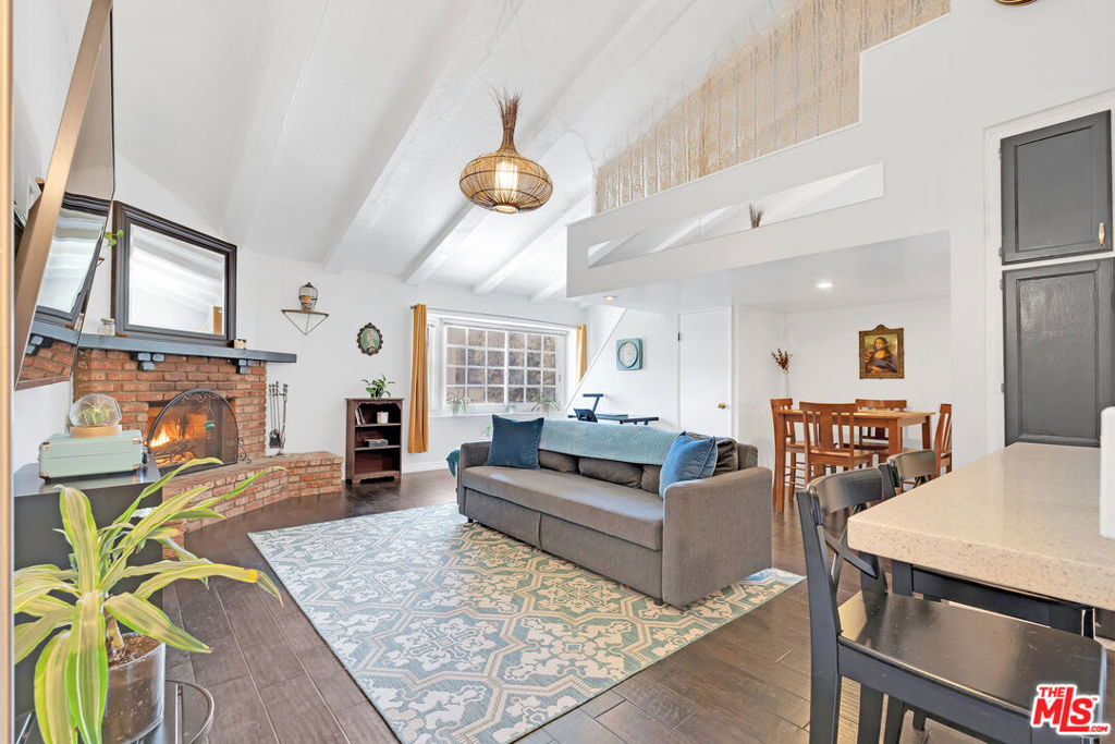 Charming and full of character, this updated condo in a boutique 8-unit building is the perfect starter home. Vaulted, exposed-beam ceilings and a brick gas fireplace create a bright, welcoming living space. Enjoy movie nights with the included 76" mounted TV or sip coffee at the breakfast bar. A spacious bonus loft adds flexibility ideal as a guest room or office. Modern upgrades include quartz countertops, in-unit laundry, and rare side-by-side parking in a secure, gated garage. Two private storage cabinets offer added convenience. The building features a secure entry, intercom system, cameras, locked mailboxes, and guest parking. HOA dues cover water, trash, sewer, earthquake insurance, landscaping, and building management. Prime location with easy access to the 101/170 freeways and just a short walk to Gelson's, Starbucks, and more. A hidden gem you don't want to miss! Falls within the Colfax School District buyer to verify eligibility.