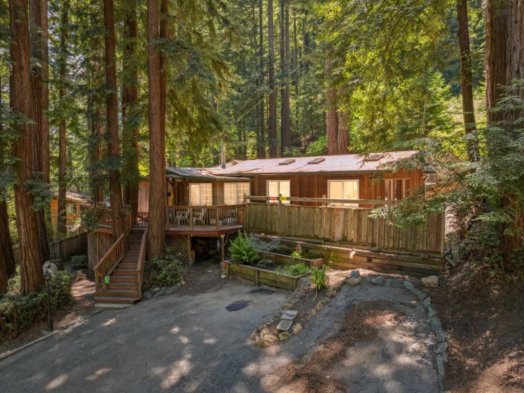 Tucked just minutes from downtown Felton, this charming mountain home offers the perfect blend of nature and convenience. Enjoy easy access to local favorites like The Grove restaurant, Wild Roots Market, world-class hiking and biking trails, and the peaceful waters of Loch Lomond Recreation Area. Plus, the beautiful beaches of Santa Cruz are just 15 minutes away. The spacious deck is ideal for summer BBQs, offering excellent views of the surrounding Redwoods. Inside, a cozy fireplace creates a warm focal point in the living room, perfect for relaxing with a good book. The open-concept kitchen overlooks the living space, so you're always part of the conversation while cooking. Skylights and large windows fill the home with natural light and frame gorgeous forest views. Almost a half an acre of land with great views. With parking for many vehicles and 2 driveways, this welcoming home is your ideal escape into the Santa Cruz Mountains.