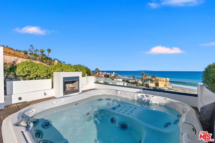 Experience the ultimate Malibu lifestyle at this ocean-view retreat in the exclusive Residences at Carbon Beach, just steps from Billionaire's Beach. Residence #7 is one of only eight homes, offering modern elegance, soaring ceilings, and abundant natural light throughout. Enjoy sweeping ocean views from every level, including the rooftop terrace with an 8-person spa and entertaining space. The main floor features an open layout with a chic breakfast nook, chef's kitchen with marble counters, top-tier appliances, dual dishwashers, prep sink, and wine fridge. The living room flows seamlessly to a private balcony for indoor/outdoor entertaining.Upstairs, the ocean-view primary suite boasts a private balcony and spa-like bath. Two additional en-suite bedrooms, a spacious sitting room, and laundry complete this level. Modern conveniences include a private elevator, and dual 2-car garages with bonus room. Located moments from Nobu, Soho, Malibu Farm, and more, this rare property blends luxury, privacy, and convenience in one of Malibu's most coveted settings.