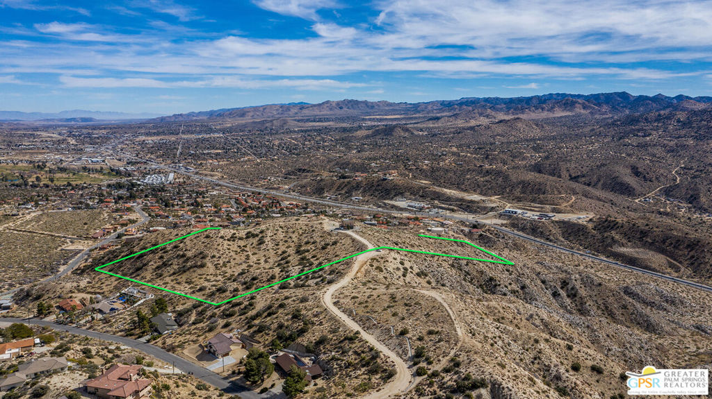 JUST REDUCED! 19.07 acres over looking the entire valley and into Palm Springs and Mt. San Gorgonio! Perfect location for that ranch for lots of privacy! Just off main paved road with water nearby and electric is run to lot. Bring the horses and ride forever! This area is zoned Hillside Reserve so you will have lots of privacy as you build and the views of mountains, canyons, city lights are really special. The night sky is as clear as you will ever see. Located just 20 minutes from downtown Palm Springs and it's amazing night life, 15 minutes from the Joshua Tree National Park entrance, 5 minutes to downtown Yucca Valley and it's great shopping and restaurants. Truly central to everything. With 19+ acres, you many spots to build that view home and have privacy! Rarely find this kind of view so close to utilities and services! This Country Club neighborhood has beautiful homes and yours can be the crown jewel at the top of the hill! Owner is licensed CA RE broker. Paved Roads, utilities available and views, this one has it all.