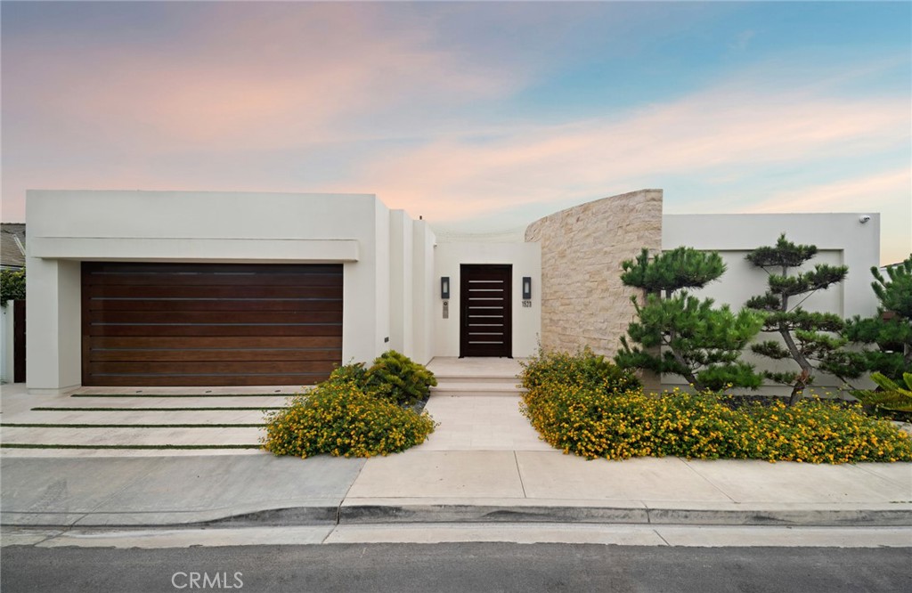 Located in one of the most coveted bluff-front locations in all of Newport Beach, this single-level contemporary estate captures unobstructed vistas stretching from the harbor entrance and Balboa Peninsula beaches to Catalina Island, Palos Verdes, and beyond. Expansive ocean horizons, vibrant sunsets, and sparkling city lights provide a captivating backdrop for everyday living. Thoughtfully designed with architectural precision, the residence showcases soaring ceilings, open living spaces, and the finest materials—cut limestone floors and walls, imported marbles, custom bronze doors and windows, and rich teak, walnut, and mahogany millwork throughout. The great room with its striking limestone fireplace and dining area opens seamlessly to the view terraces, covered alfresco lounge, lap pool, and spa, embodying effortless indoor-outdoor living. A gourmet kitchen is equipped with professional-grade appliances, marble countertops, a butler’s pantry, and walls of glass that draw the outdoors in. The private primary suite is a true retreat, appointed with curvilinear walnut-paneled walls, a spa-inspired marble bath, and a custom-fitted dressing room. Additional accommodations include a guest suite with ensuite bath, a den with bespoke built-ins, and a two-car garage. Set within the highly sought-after community of Irvine Terrace, this residence offers rare front-row living just moments from Newport Harbor, the Newport Beach Country Club, and world-class shopping, dining, and entertainment at Fashion Island.