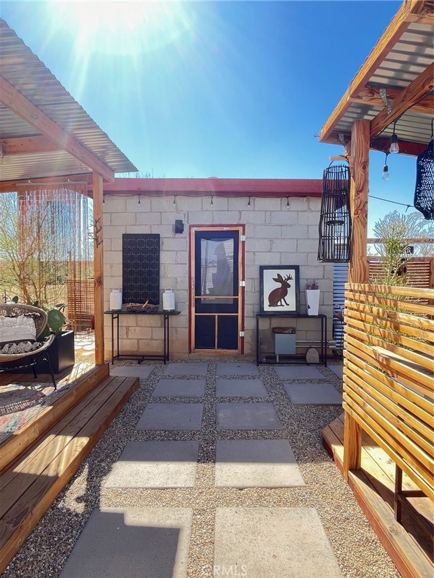 Tucked away on five private acres just ten minutes from downtown Joshua Tree, this hidden gem is a creative’s dreamscape — where art, nature, and possibility converge.

What began as an original block-built recreational cabin has evolved into a thoughtfully reimagined desert retreat, blending vintage charm with modern comforts. The main cabin offers upgraded essentials including a new kitchen with stove, sink, refrigerator, and pantry, plus washer and dryer in the large shed hooked up and ready to go. The beginnings of a primary suite and full bath are in place, ready for your personal touch to bring the vision to life.

Outdoors, inspiration flows freely. A covered patio serves as the perfect space for painting, gathering, or dining beneath the stars. An original 1960s camper has been transformed into a cozy guest suite with heating, cooling, and a fully remodeled functioning bathroom. Two large shipping containers expand the creative potential — one currently used for storage, the other waiting to become your next art studio, gym, or meditation space.

With public water, a brand-new 200 AMP electrical panel, and room to grow, this property offers both comfort and endless opportunity. Whether you’re seeking a private retreat, an artist’s compound, or a place to build your future desert home, this is where your Joshua Tree story begins. Zoned Recreational Cabin (Rec Cabin), not Single Family Residential (SFR) This property is available for purchase CASH ONLY - will not qualify for a loan.