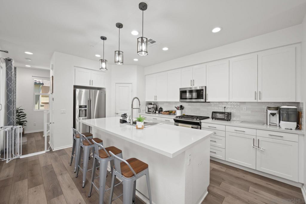 Experience the epitome of comfort and style in this 4-bedroom, 3.5-bathroom 1,824 square foot home located in the heart of Oceanside. This home was built in 2021 and is a corner unit nestled within a secure gated community, offering a serene living environment. The home boasts central heat and air, ensuring year-round comfort. The kitchen is a chef's dream with luxury granite countertops, designer soft-close cabinets, stainless steel appliances, and a large pantry providing ample storage space. The luxury laminate wood flooring extends from the kitchen to the bathrooms and living room, adding a touch of elegance. The bedrooms are carpeted for added comfort, with the primary bedroom featuring an oversized walk-in closet. A unique feature is the Jack and Jill bathroom connecting the other two upstairs bedrooms, providing convenience and privacy. The home also includes a washer and dryer on the second floor making doing laundry a breeze. The attached 2-car garage offers secure parking with plenty of space for storage. Outdoor spaces include a private patio off of the front door and a large covered patio on the second floor, perfect for relaxation or entertaining. You will also have access to a community pool, perfect for those warm days! This home truly offers a luxurious and convenient lifestyle. Don't miss out on the opportunity to make this your new home!