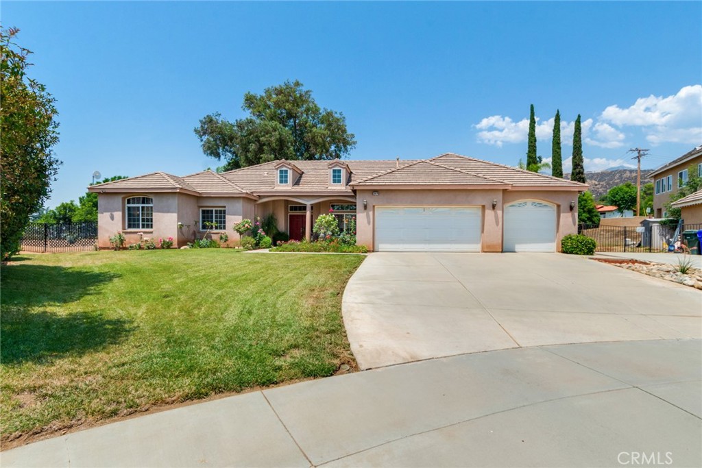 This terrific home in upper Yucaipa is situated on a cul-de-sac and enjoys a near half acre lot with fruit trees, berry bushes and many flowering plants. The home is situated with a large drive way and the lot is fenced and cross fenced. The front porch is inviting with a double door entry with transom window above. This 2435 sf home features 3 bedrooms, an office and large living areas. The interior layout is spacious with separate living and dining areas, glass French doors can provide separation or privacy from the family area. The family room enjoys a fireplace and is open to the center island kitchen. Stainless steel appliances, Corian countertops, a large pantry, breakfast bar and an informal eating area make up a very functional gathering area. The laundry is off of the kitchen making multi tasking easier. The high ceilings and abundance of natural light bring cheer and warmth to the home. The primary suite enjoys a large spa style bath with soaking tub, separate shower, dual sinks and attached is a spacious walk-in closet. A rear patio with an island is great for outdoor fun. Meandering paths through the garden are nicely laid out with butterflies and hummingbirds as your frequent visitors. Fenced separately is a large area that has many possibilities, fruit orchard, sport court, a shop or an ADU. There is plenty of room and locations for a pool as an additional option. This large single story home on .49 of acre has so much to offer and can fit into many lifestyles. Bring your needs, your hopes and dreams and watch the vision come together.