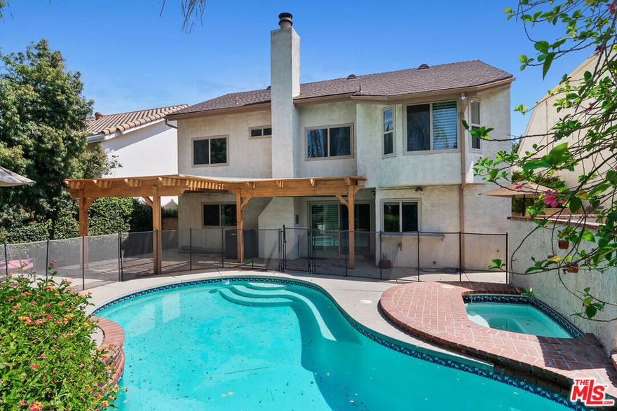 Nestled on a serene tree-lined street in the heart of Tarzana, this beautifully updated California traditional offers 5 bedrooms and 3 bathrooms across two spacious levels. A formal entry opens into a light-filled interior with soaring ceilings, leading to the elegant living and dining rooms, perfect for gatherings and entertaining. The updated kitchen boasts quartz countertops, a custom glass tile backsplash, double pantry, and a charming breakfast nook. Just off the kitchen, the inviting family room features a classic brick fireplace and sliding glass doors that open to a private backyard retreat. Outdoors, enjoy a heated pool and jacuzzi, a pergola-covered patio ideal for al fresco dining, and a cozy lawn perfect for relaxation or recreation. The main level includes a versatile bedroom with a full bath, along with a spacious laundry room. Upstairs, the expansive primary suite offers a large ensuite bath with a soaking tub, separate walk-in shower, and generous closet space. Three additional bedrooms share a full bath with dual sinks. Additional upgrades include new front siding, a new furnace, a new pool & spa heater and a new water heater. This home combines comfort, style, and functionality in one of Tarzana's most desirable neighborhoods, an exceptional opportunity not to be missed.