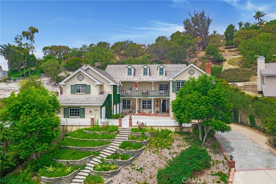 Nestled in the hillside stands this gorgeous 4973 sq. ft. 4 bedroom 4 bath house with enough charm, glamour, and flair to satisfy discerning buyers looking for a “find.” Mirroring the outside landscape, the inside oversized rooms lend a free, open feel. Elevated rustic meets muted elegance in the incredibly large yet highly functional kitchen. These features continue throughout with tasteful touches like exposed beams, beautiful wide molding curved archways, and wooden floors. Who doesn’t appreciate a grand yet graceful stairway like this beauty? Likewise, for anyone who has always wanted a roomy walk-in closet with built-in organizers, here is it and it can be yours. Rooms throughout offer a myriad of possibilities for everyday living and entertaining. A huge upstairs balcony offers picturesque views as do the large windows throughout. Outside living is further enhanced by the downstairs large pool and patio area. Terracing and even a white picket fence complete the beauty of this property.