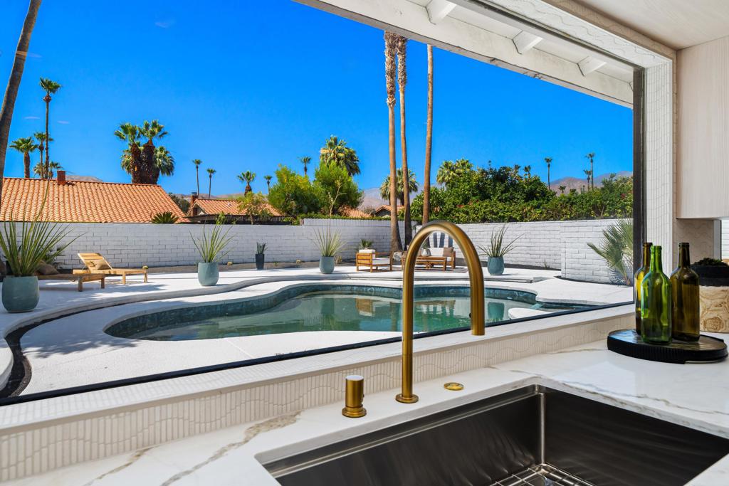 Luxury, craftsmanship, rich design: these are the words that describe this exquisitely renovated residence nestled within a quiet, hidden enclave-offering a combination of privacy and convenience, all with no HOA just moments from the heart of Rancho Mirage, while still being minutes from Palm Springs. Upon entry, you're greeted by a striking 30-ft marble stone walkway that sets the tone for the caliber of design and finish quality of the home. When you reach the living space, the refined open-concept floor plan impresses with soaring vaulted ceilings, smooth-finish drywall with a spray paint finish, and wide-plank scratch-resistant white oak luxury vinyl flooring. Perfectly situated on a large north to south lot, the space is comfortably filled with natural light during the day and enhanced by dimmable LED recessed lighting at dusk. Thinking of adding an ADU? This is the perfect lot. The chef's kitchen is a true centerpiece, featuring a professional-grade ZLINE dual fuel range, a sleek waterfall-edge oversized island with a built-in wine fridge, and a stunning 10-foot architectural window showcasing breathtaking backyard views. Custom white oak cabinetry with 9-ply birch boxes and drawers, luxury quartz countertops by Tile Designs by Fina, European brass fixtures, and a limestone backsplash complete this gourmet space with timeless sophistication. Designed by Nicholas Lawson, a Coachella Valley local. Retreat to the spa-inspired primary suite and bathroom with 360-degree designer tile, walk-in shower featuring dual solid-brass tower faucets, picture window with a view of the private backyard, copper penny tile flooring with copper glass grout. Both bathrooms feature a large walk-in shower, smart toilets with bidets and auto-open, and double sink vanities with solid brass fixtures. Expansive 10-foot sliding glass doors open effortlessly to a private backyard oasis, complete with a sparkling PebbleTech pool, tiered entertaining zones, and a cool-technology coated deck perfect for warm desert days. All of this set against the dramatic backdrop of the San Jacinto Mountains. Additional upgrades include a brand-new 18.5 SEER2 high-efficiency electric heat pump with a 10-year compressor warranty for added peace of mind. Centrally located near sought-after destinations including Cotino - Disney's Storyliving community, world-class golf, upscale dining, and premier shopping, this home delivers luxury desert living with zero compromises. Staging can be purchased